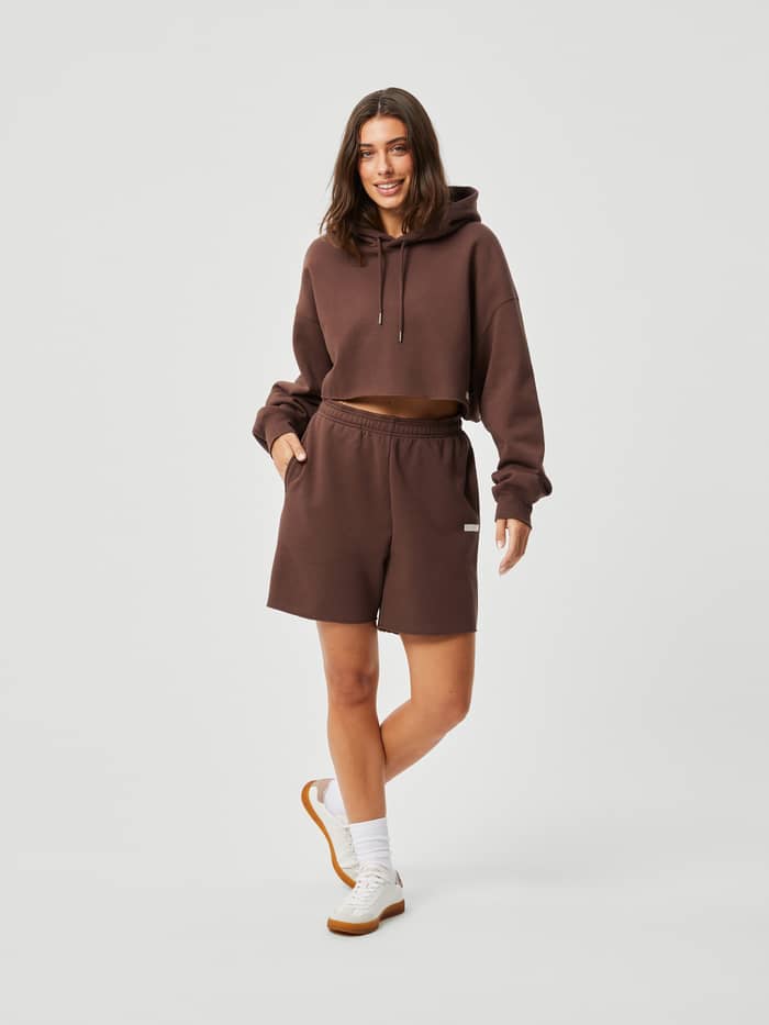 Studio Oversized Shorts i French Toast (Brun) för dam sedda framifrån med en matchande kort hoodie i oversized-passform.