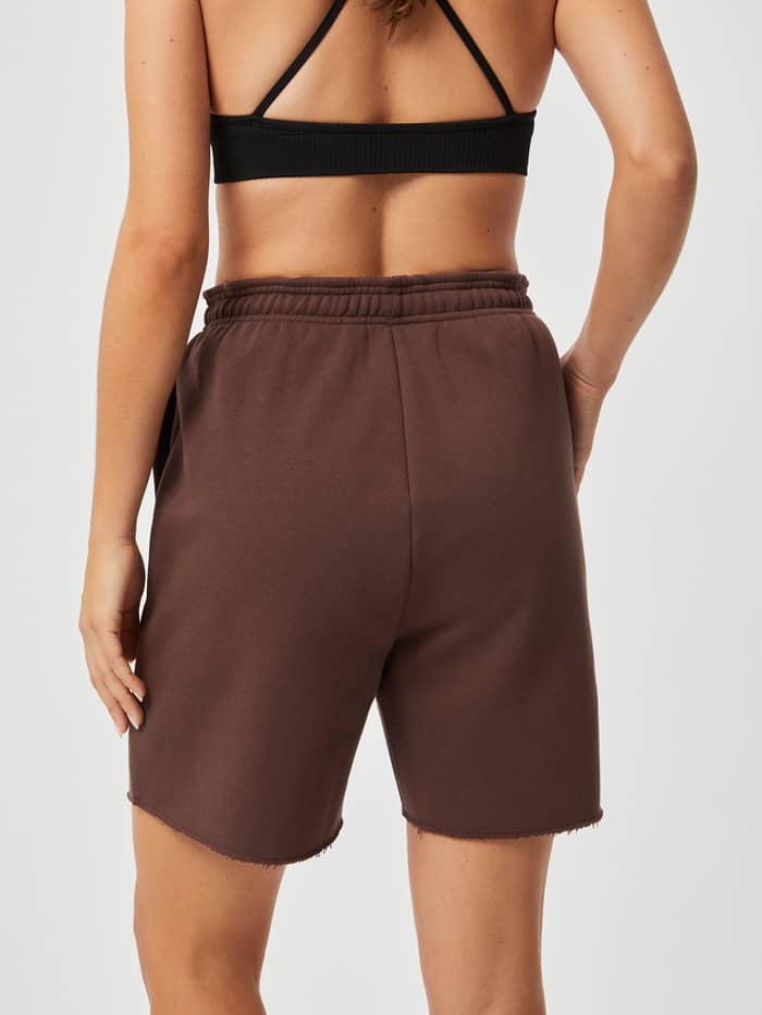 Back view of a model wearing the Björn Borg Studio Oversized Shorts in French Toast (Brown) with a high, ribbed waist. - Image 3