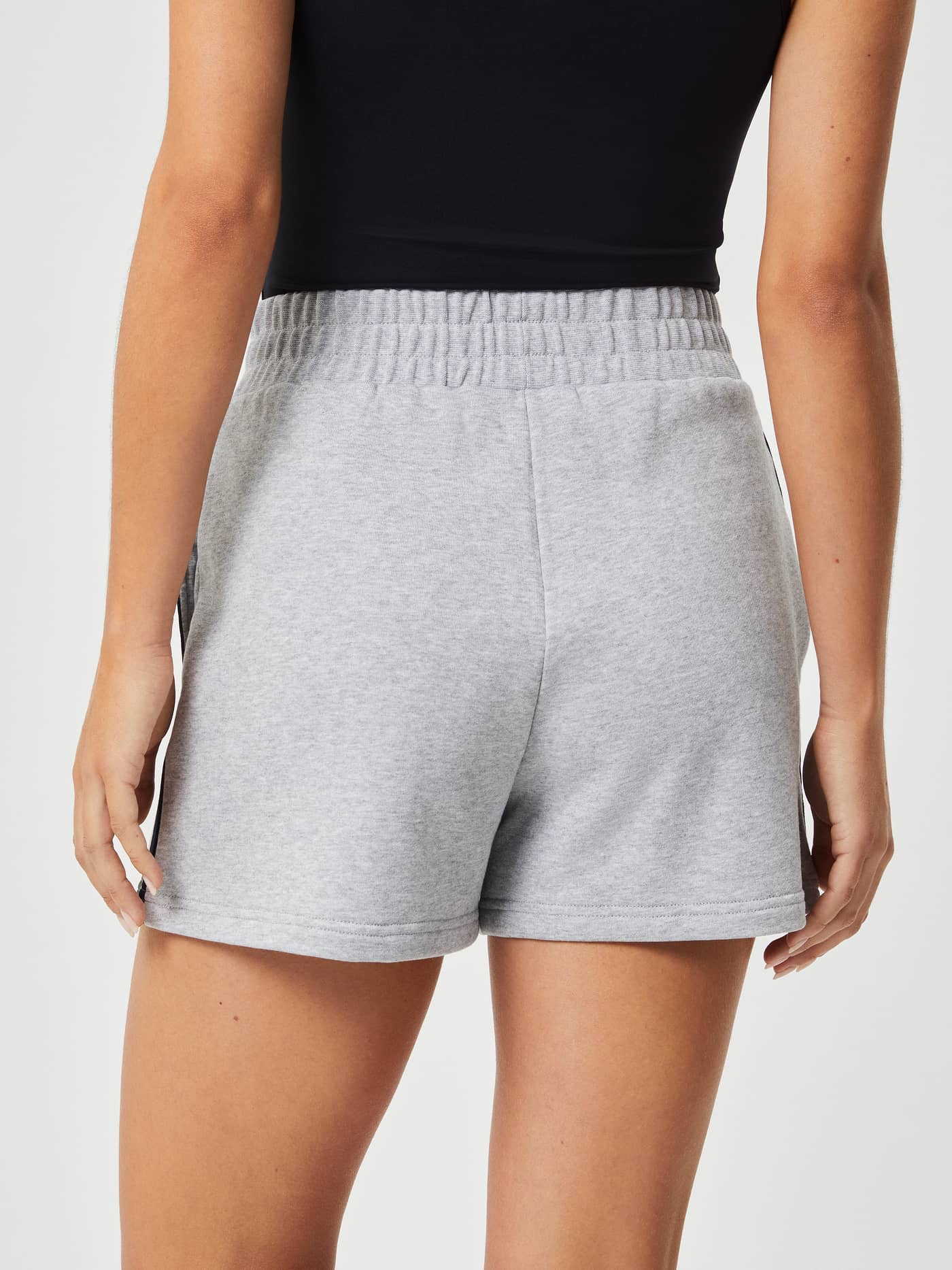 Back view of a woman wearing Björn Borg Ace French Terry Track Shorts in Light Grey Melange (Grey) for tennis style and fit. - Image 3