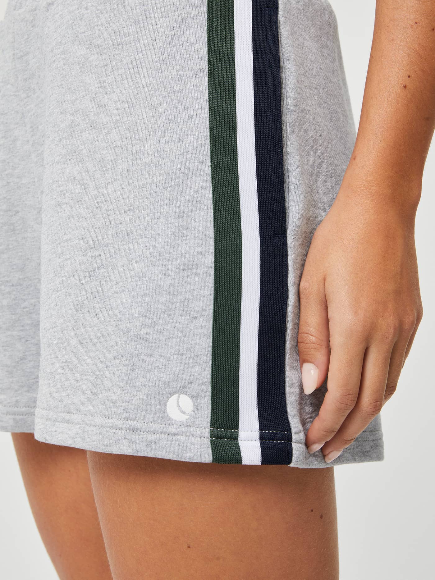 Close-up of the women's Ace French Terry Track Shorts in Light Grey Melange (Grey) with side stripes and tennis ball logo. - Image 4