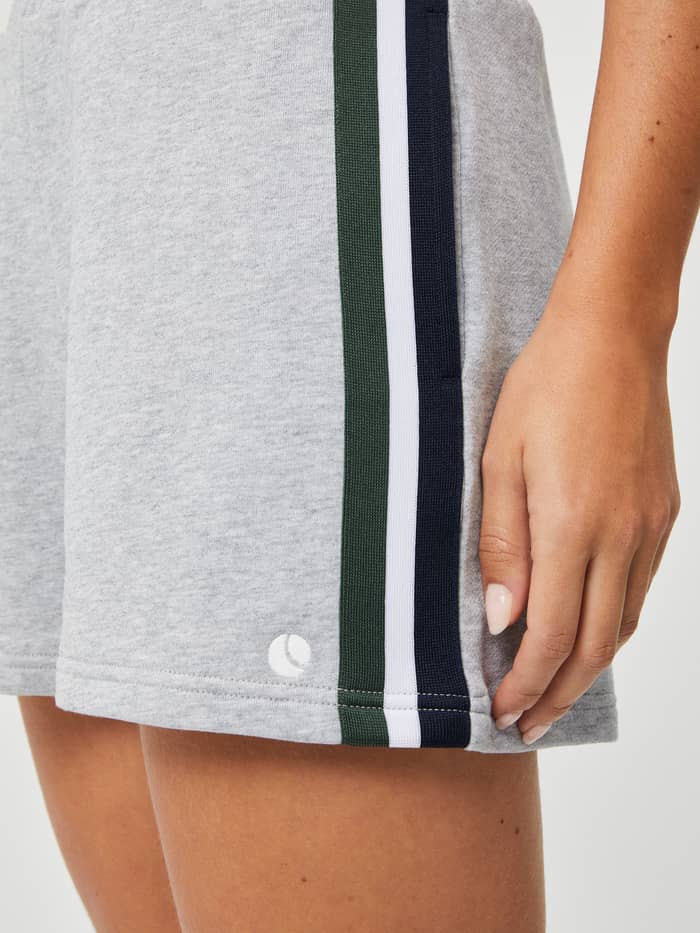 Close-up of the women's Ace French Terry Track Shorts in Light Grey Melange (Grey) with side stripes and tennis ball logo. - Image 4