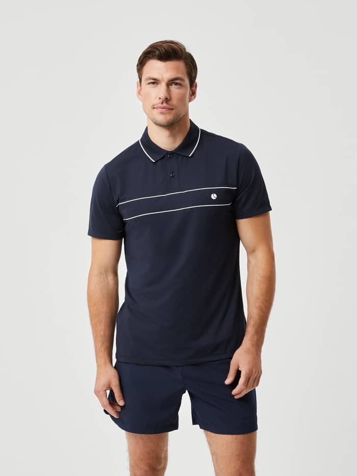 Ace Light Polo i Night sky (Blå) set forfra, en åndbar performance-poloskjorte til tennis med et hvidt logo.