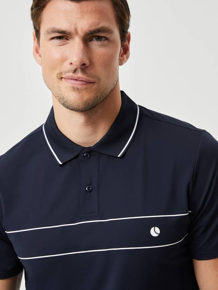 Ace Light Polo i Night Sky (Blå) set i nærbillede med tennisboldlogo, en funktionel og stilfuld polo til tennis.