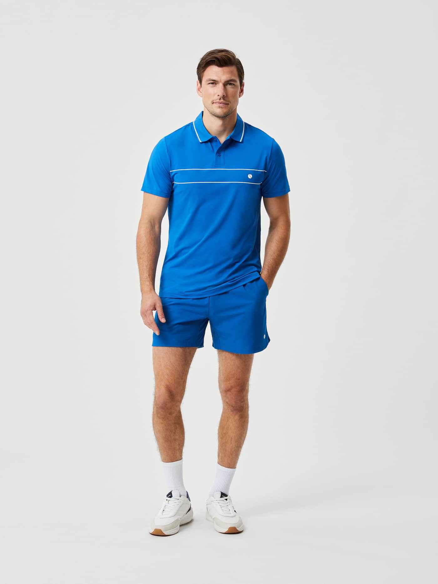 Front view of a man in the Björn Borg Ace Light Polo in Classic Blue (Blue), a high-stretch tennis shirt with a white logo. - Image 4