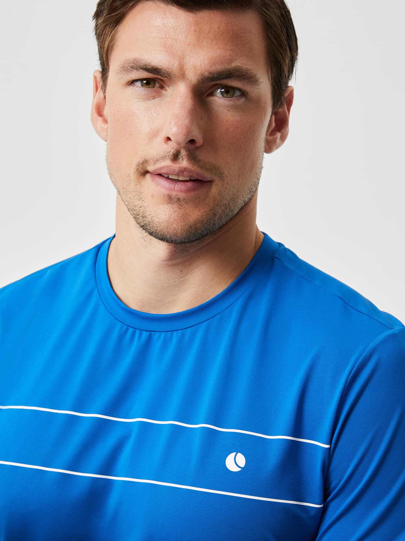 Close-up front view of a man wearing the Björn Borg Ace Light T-Shirt in Classic Blue (Blue) for tennis performance. - Image 4