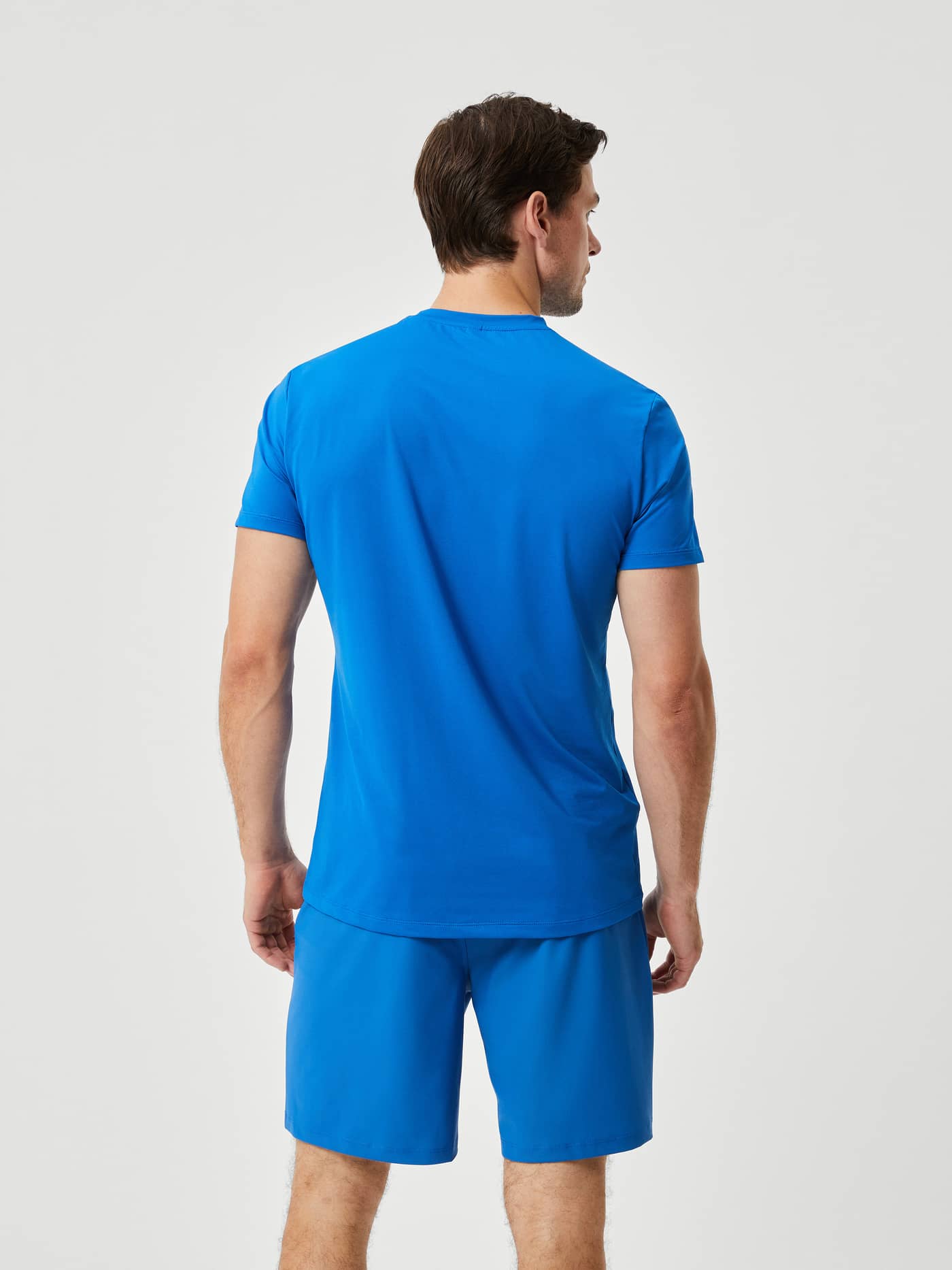 Back view of a man wearing the high-stretch Björn Borg Ace Light T-Shirt in Classic Blue (Blue) for tennis performance. - Image 2
