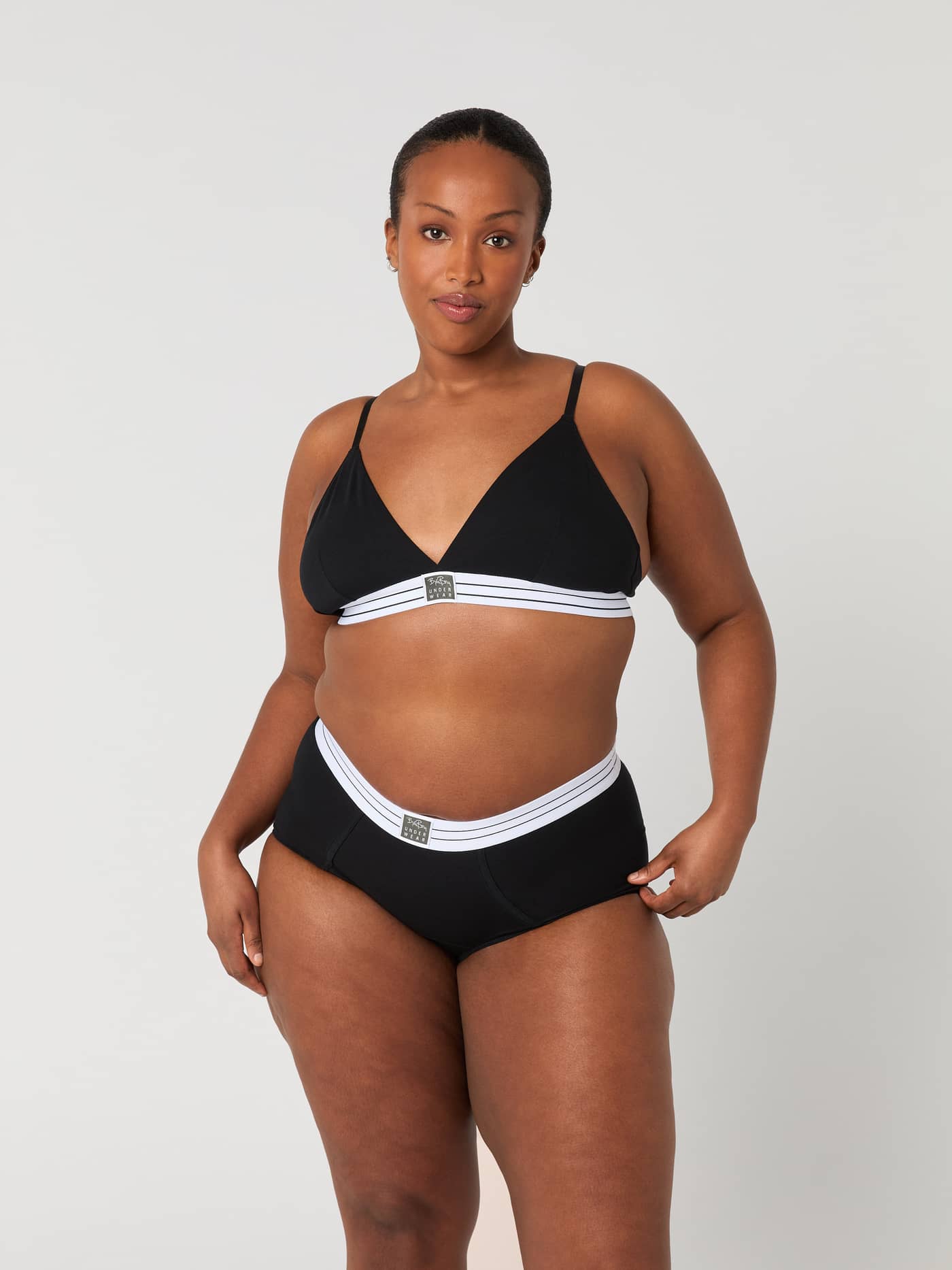 Vorderansicht eines Models im schwarzen Core Original Triangle Bra aus weichem Baumwoll-Stretch mit elastischem Logoband. - Image 4