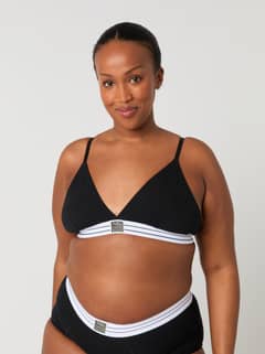 Vorderansicht einer Frau im Core Original Triangle Bra in Schwarz mit weißem Logo-Bund für einen bequemen Sitz. - Image 3