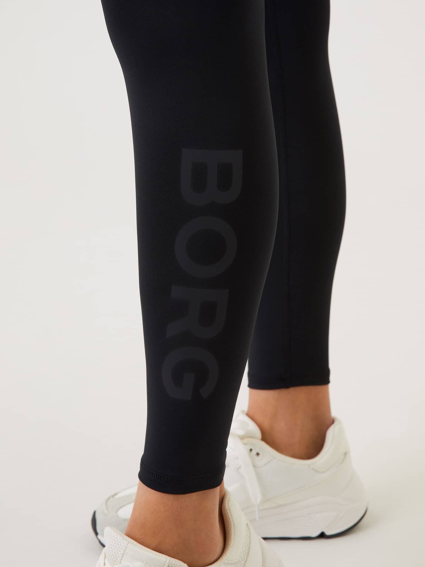 Close-up of the tonal black logo on the slim-fit Borg Logo Tights in Black Beauty (Black) for women's training. - Image 4