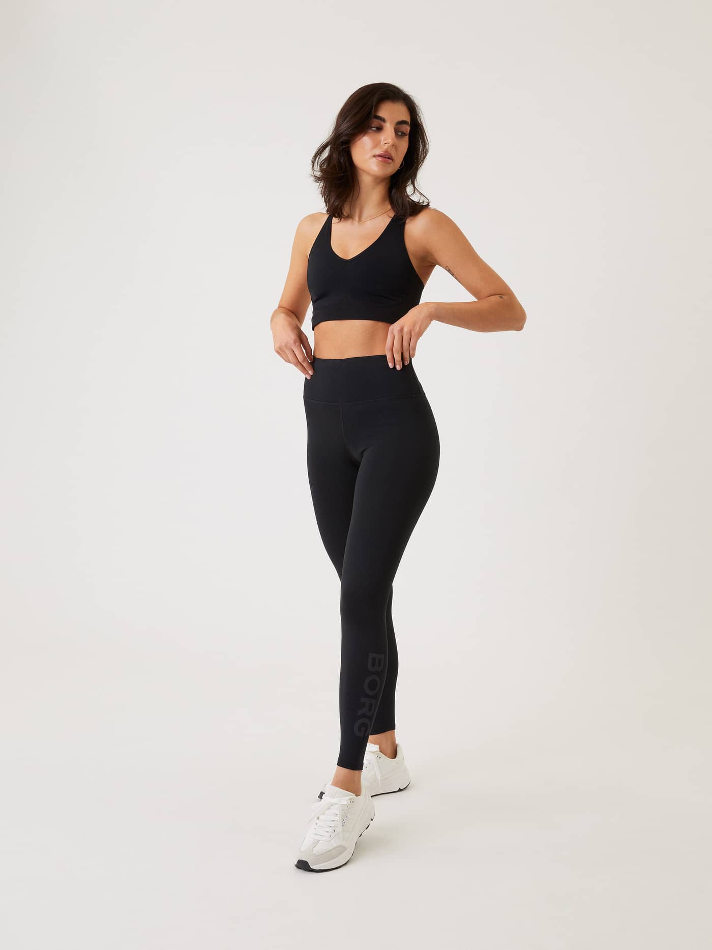 Full-body front view of a woman wearing high-waisted Björn Borg Logo Tights in Black Beauty (Black) for stylish training. - Image 1