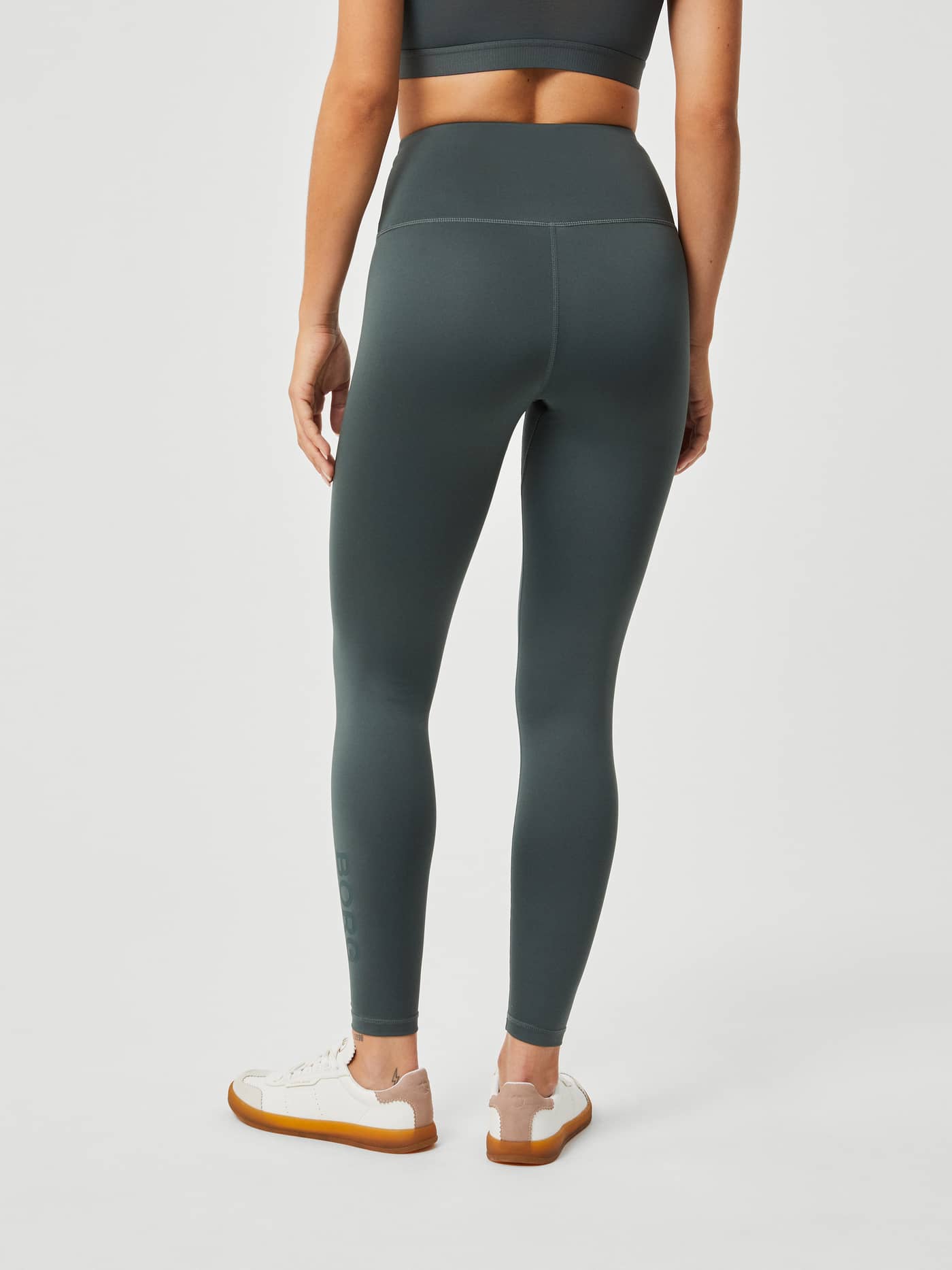 Back view of a model wearing high-waist Borg Logo Tights in Urban Chic (Green) for a sleek and supportive training fit. - Image 3