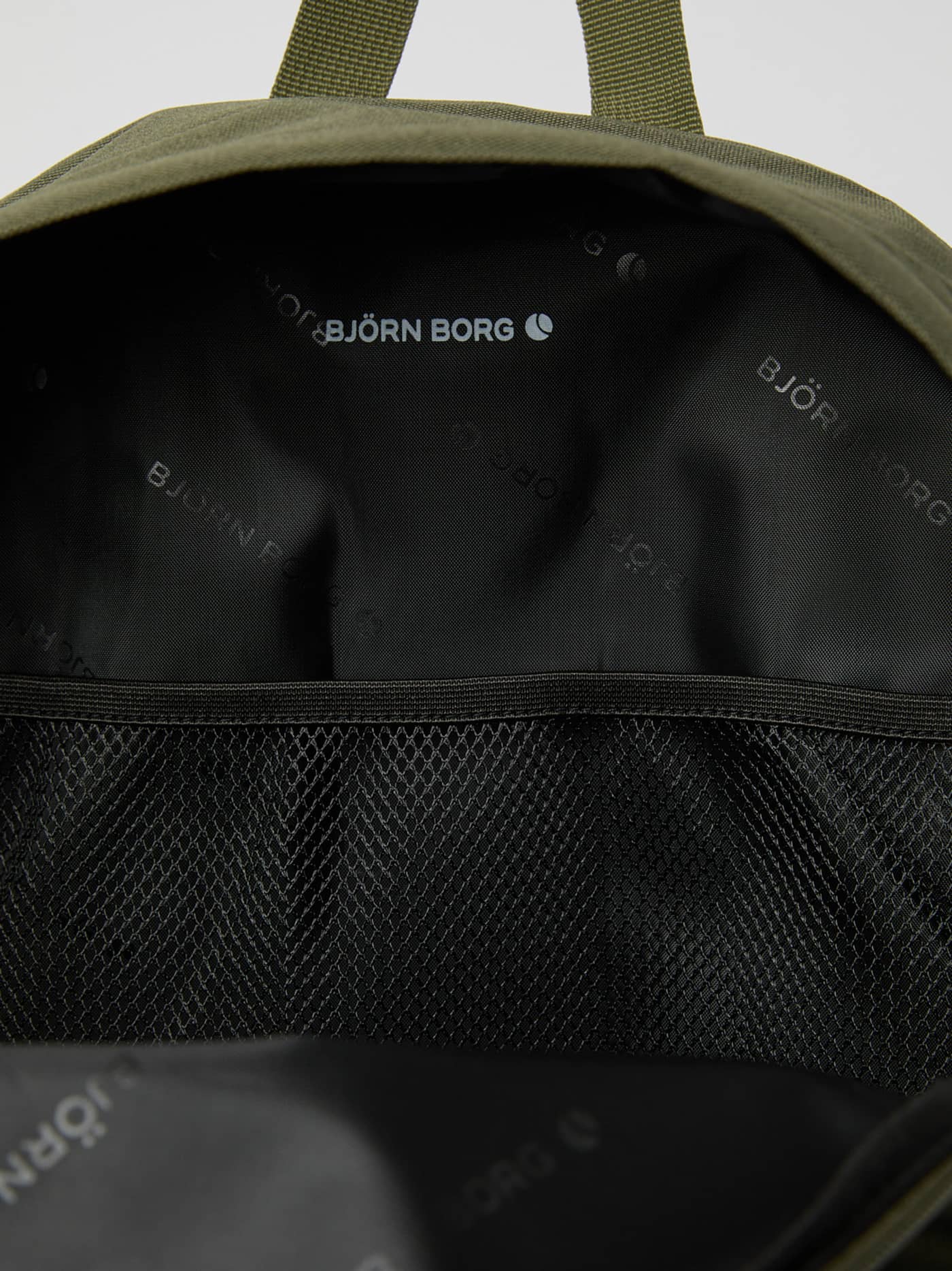 Gros plan sur la poche intérieure en filet et la doublure à logo blanc du Borg Stripe Backpack en Kalamata (Vert). - Image 4