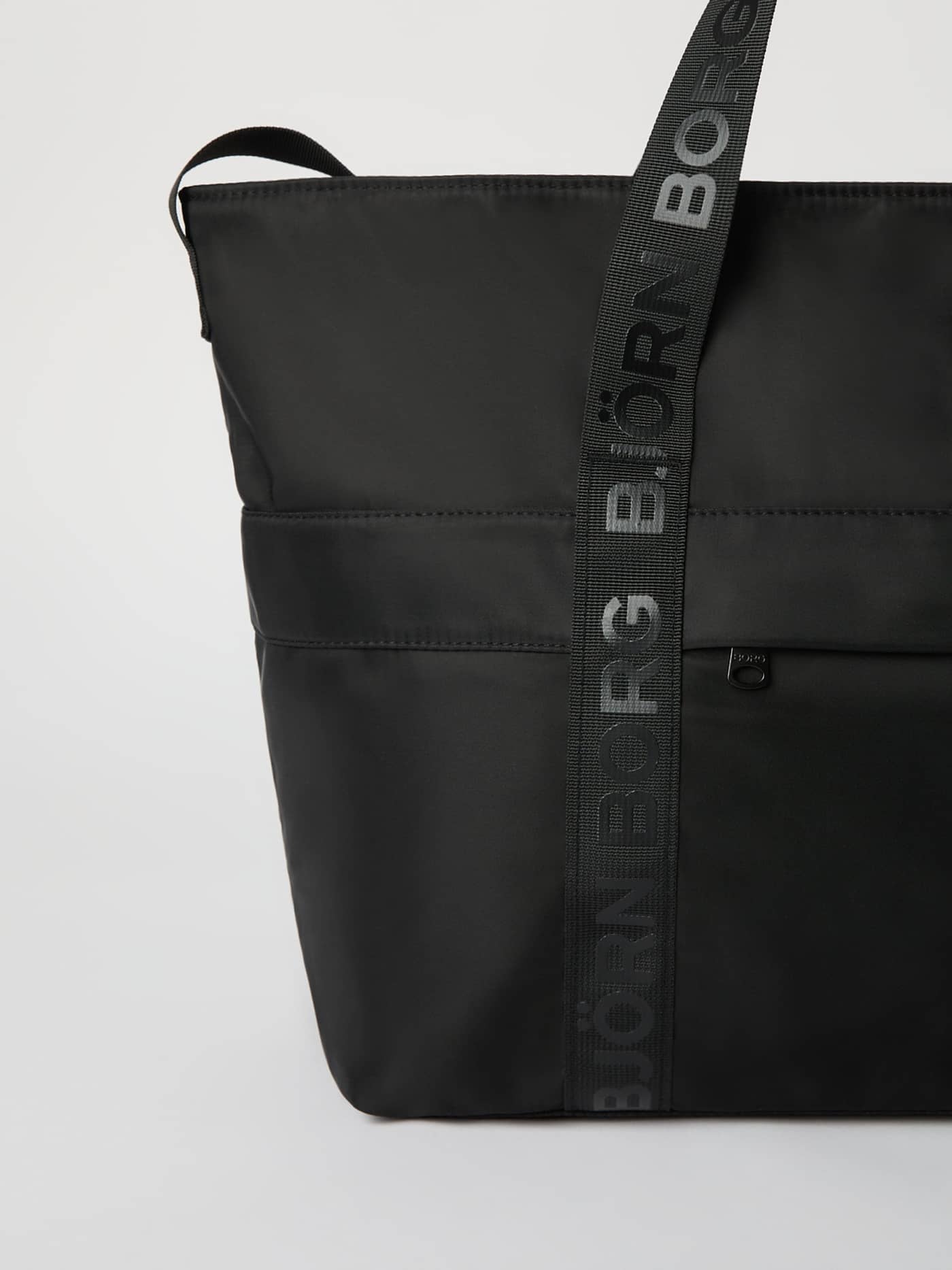 Detailed view of the Borg Classic Tote 27L in Black Beauty (Black) featuring durable polyester and a grey logo hand strap. - Image 3