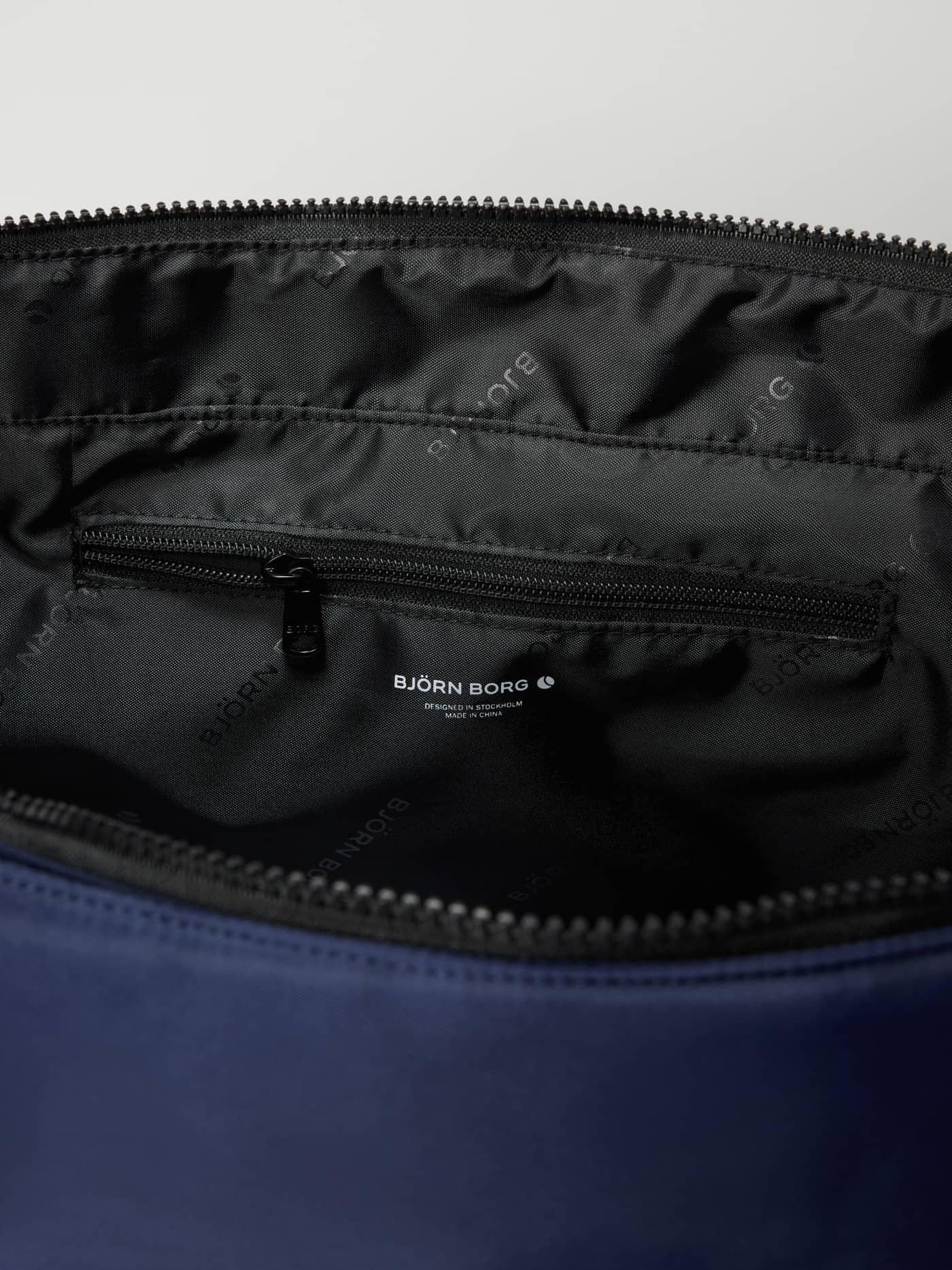 Borg Classic Tote 27L in Dress Blues (Blue) features a black branded lining with a white logo and inner pocket for training. - Image 3