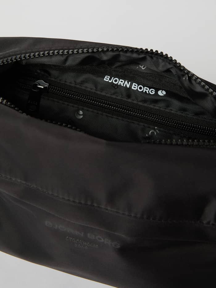 Interiör av Borg Daily Crossover Bag i Black Beauty (Svart) med en ficka med blixtlås och vit logotyp. - Image 4