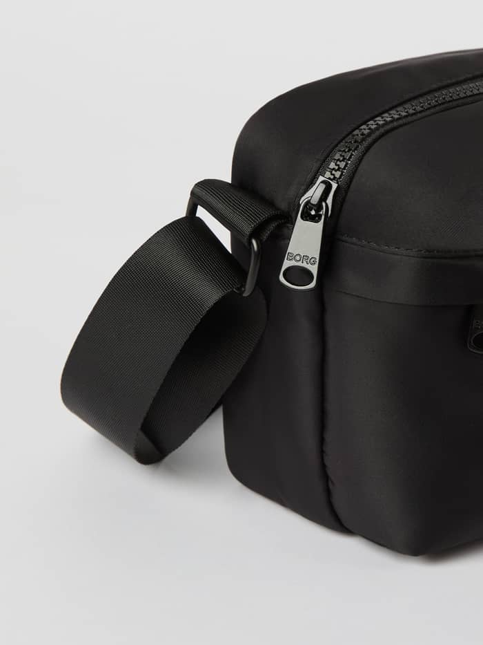 Närbild på Borg Daily Crossover Bag i Black Beauty (Svart) i polyester med en silverfärgad BORG-logotyp. - Image 3