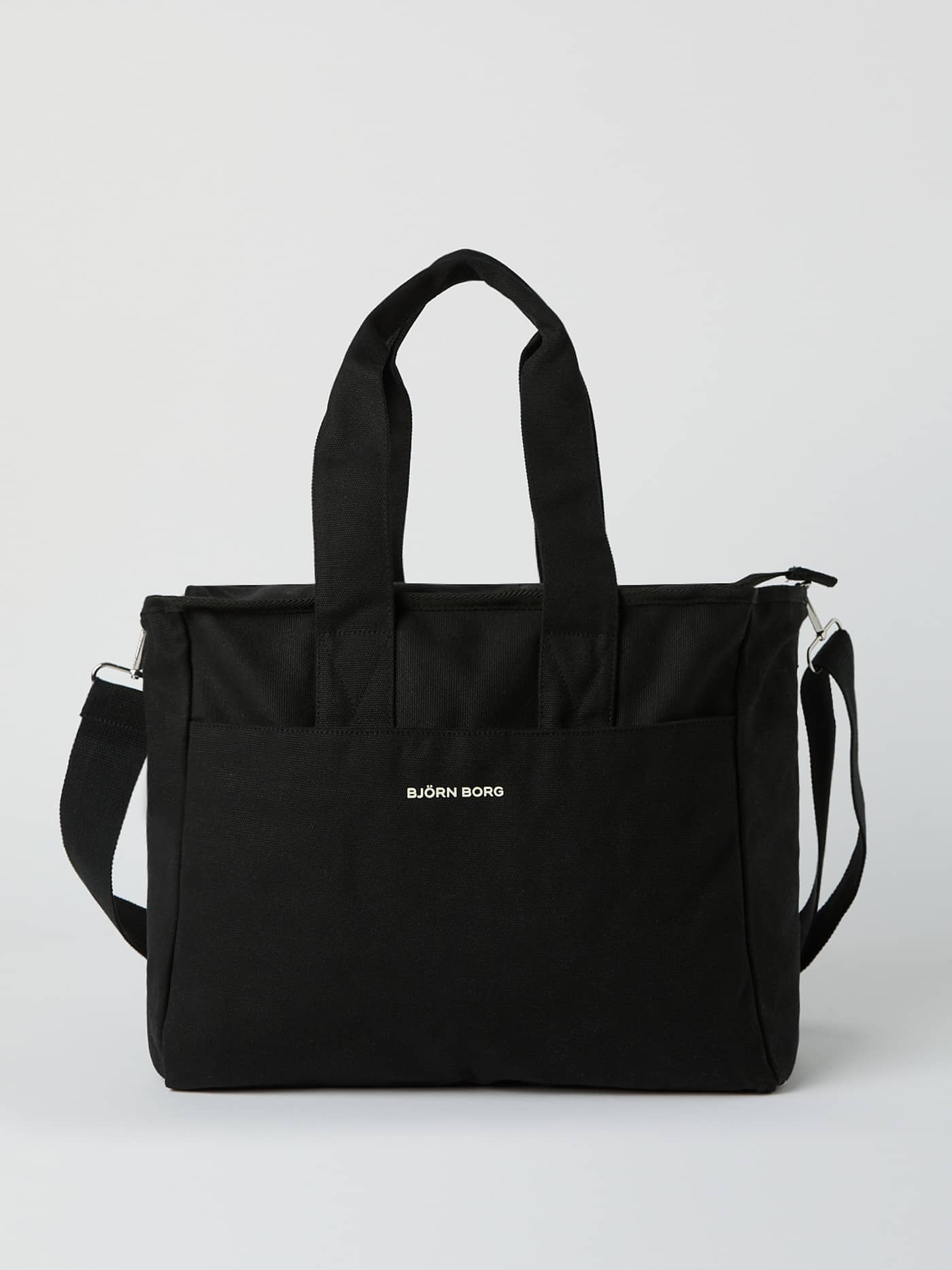 Front view of the Studio Canvas Tote 27L in Black Beauty (Black), featuring durable cotton canvas and a white logo. - Image 1