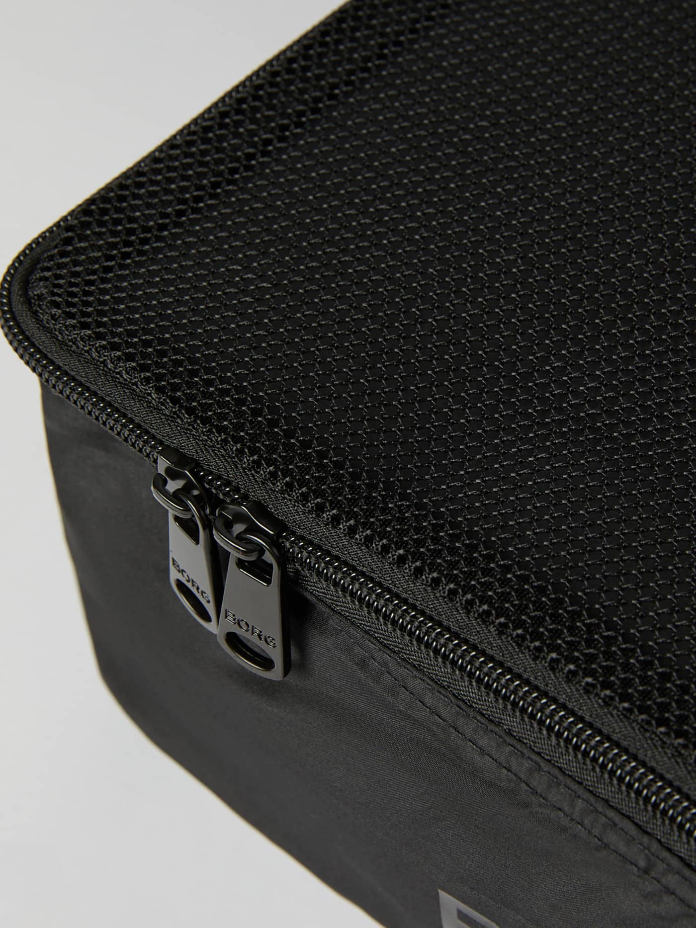 Detailed close-up of the Borg Travel Garment Cases in Black Beauty (Black) with mesh panels and dual black BORG zippers. - Image 3