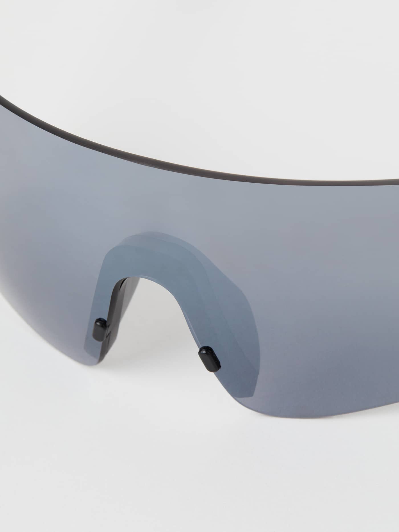 Detailed close-up of the black Running Sunglasses, featuring the shield lens and adjustable MEGOL rubber nose pad. - Image 4