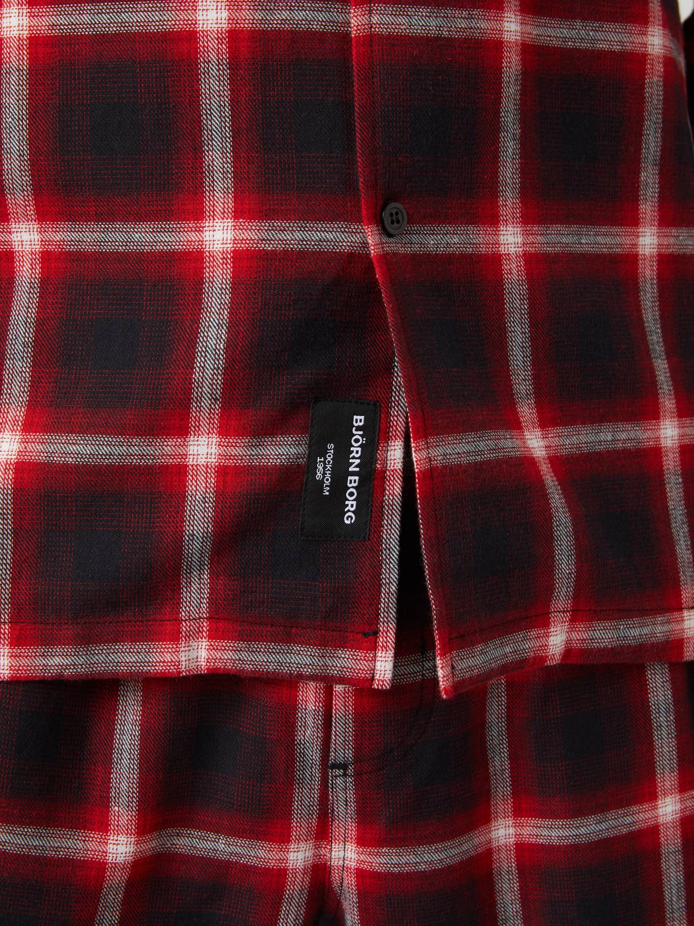 Close-up of the Björn Borg Core Flannel Pyjama Shirt in a red and black check pattern, showing the soft fabric and logo tag. - Image 5