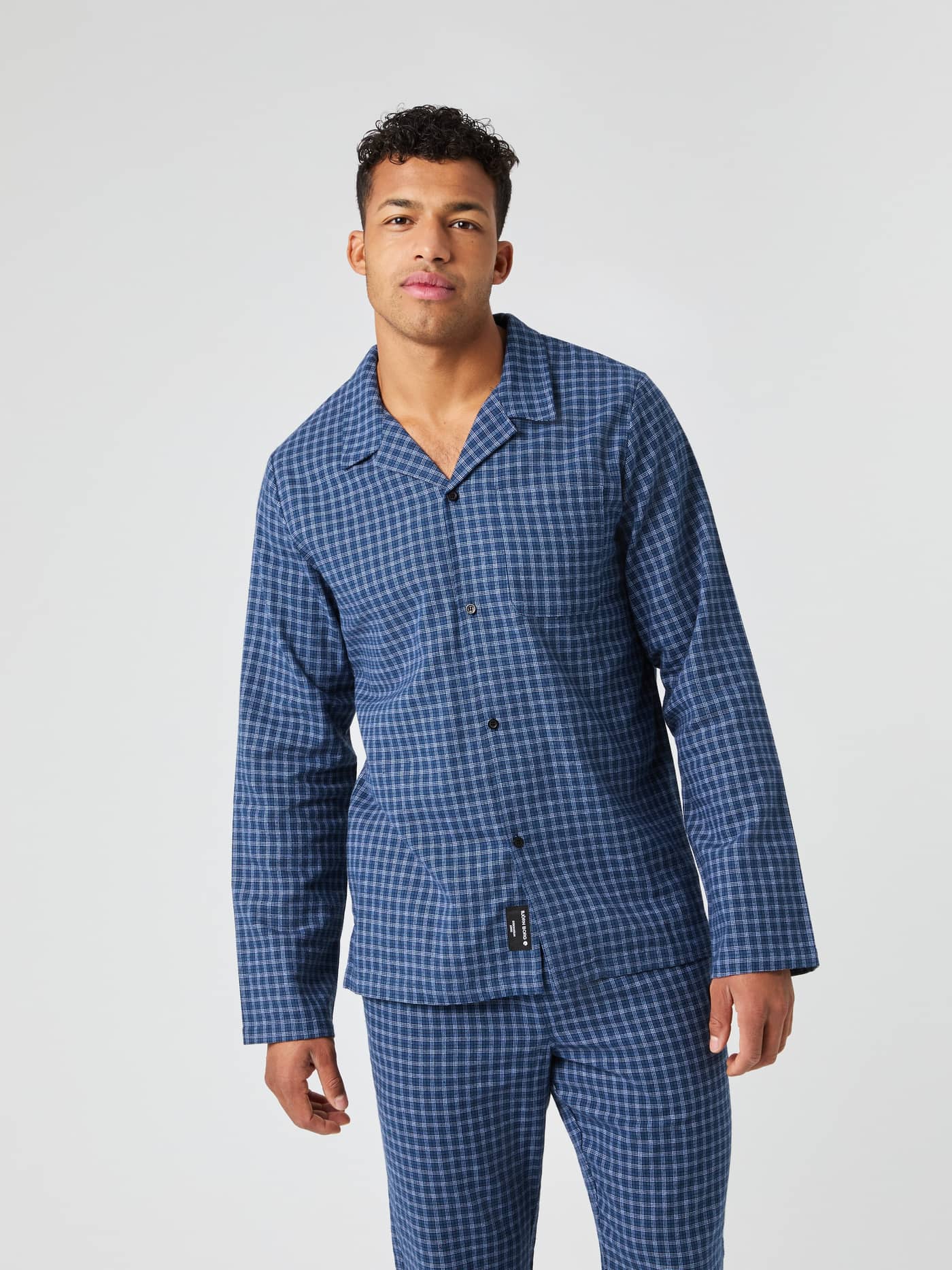 Front view of a model wearing the blue Björn Borg Core Flannel Pyjama Shirt and matching pants against a grey background. - Image 2