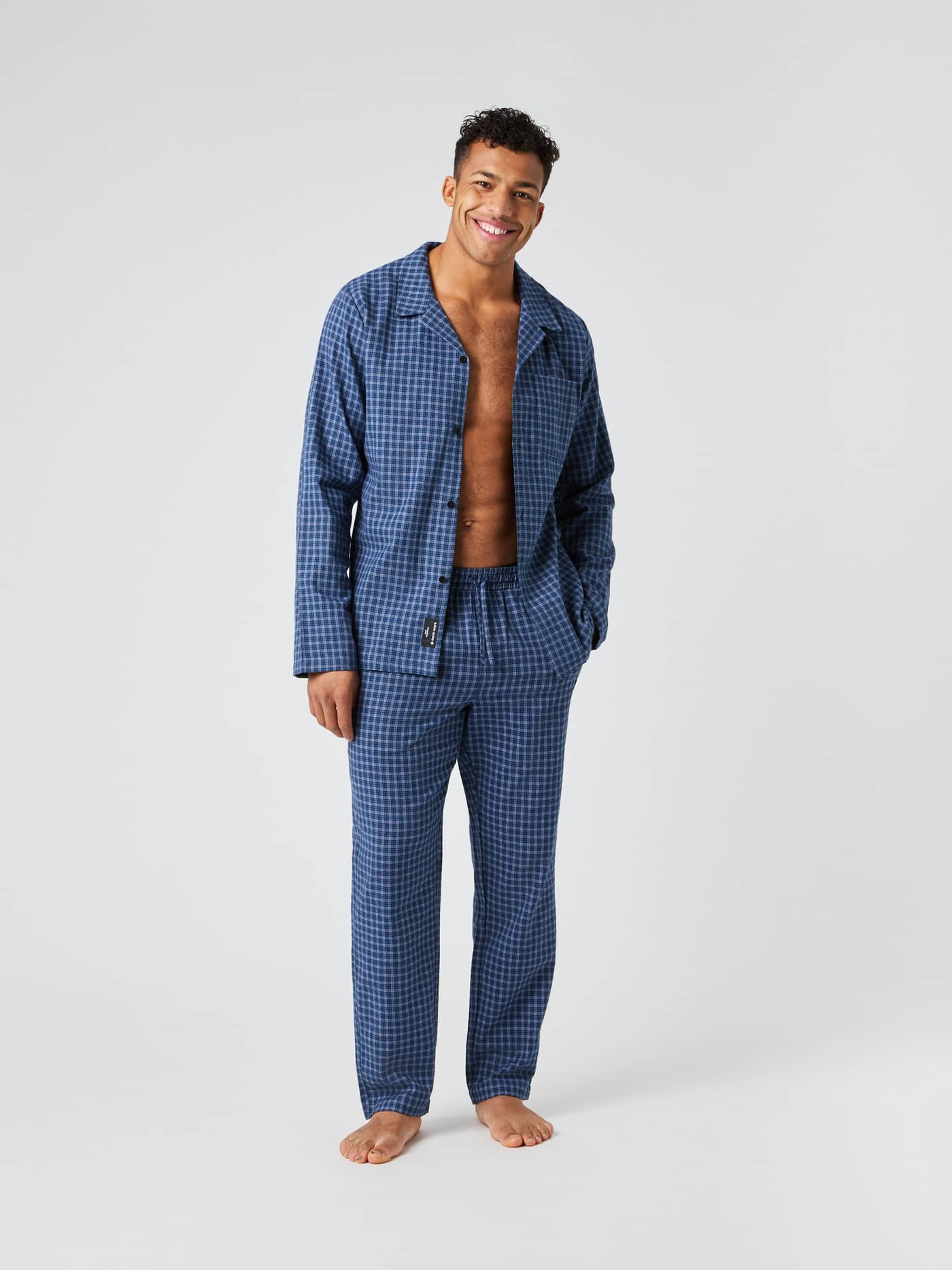 Full body shot of a male model wearing the blue checkered Björn Borg Core Flannel Pyjama Shirt with matching pants. - Image 4