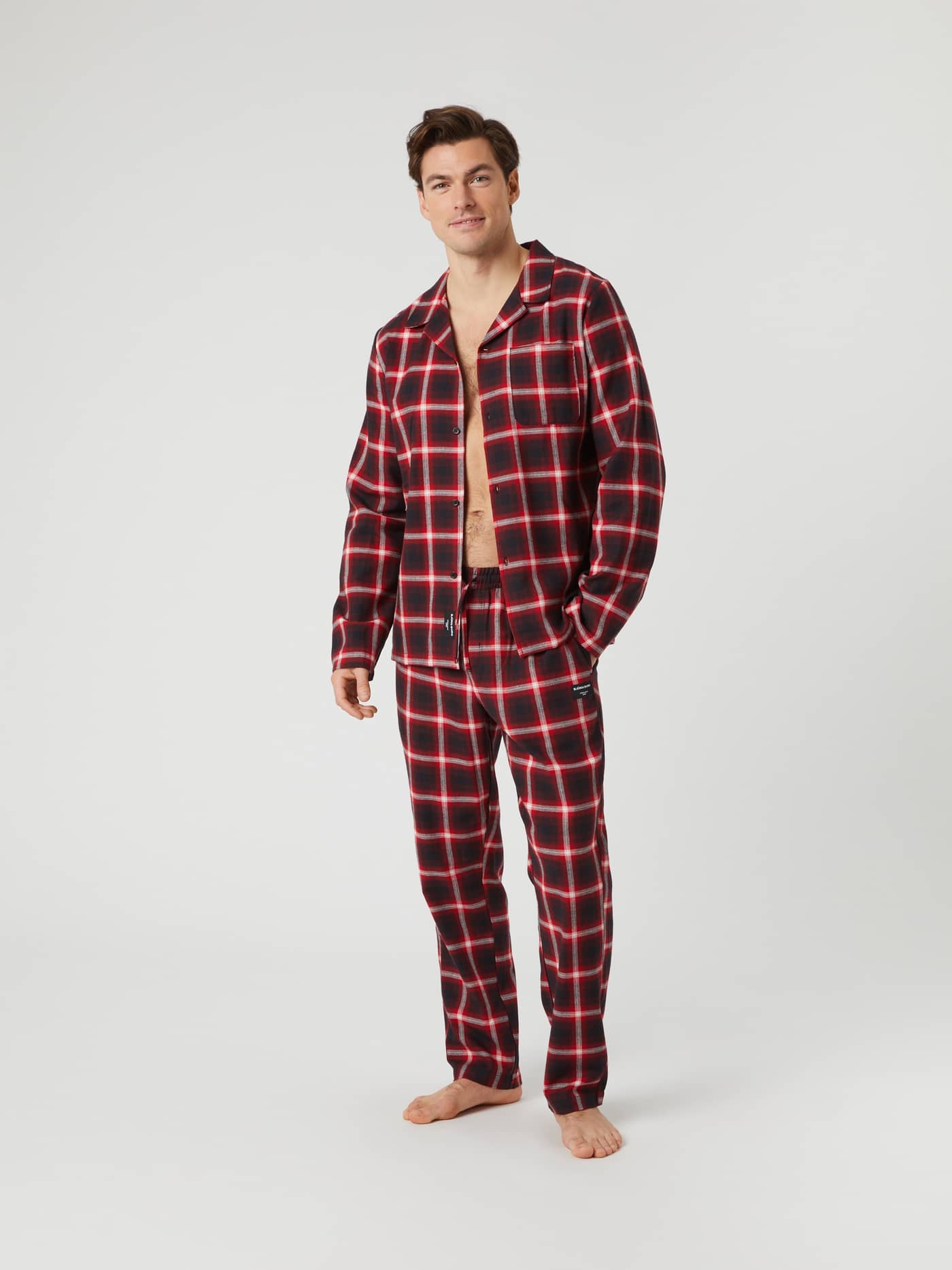 Full length shot of a model wearing the red and black lumber check Björn Borg Core Flannel Pyjama Shirt and matching pants. - Image 3