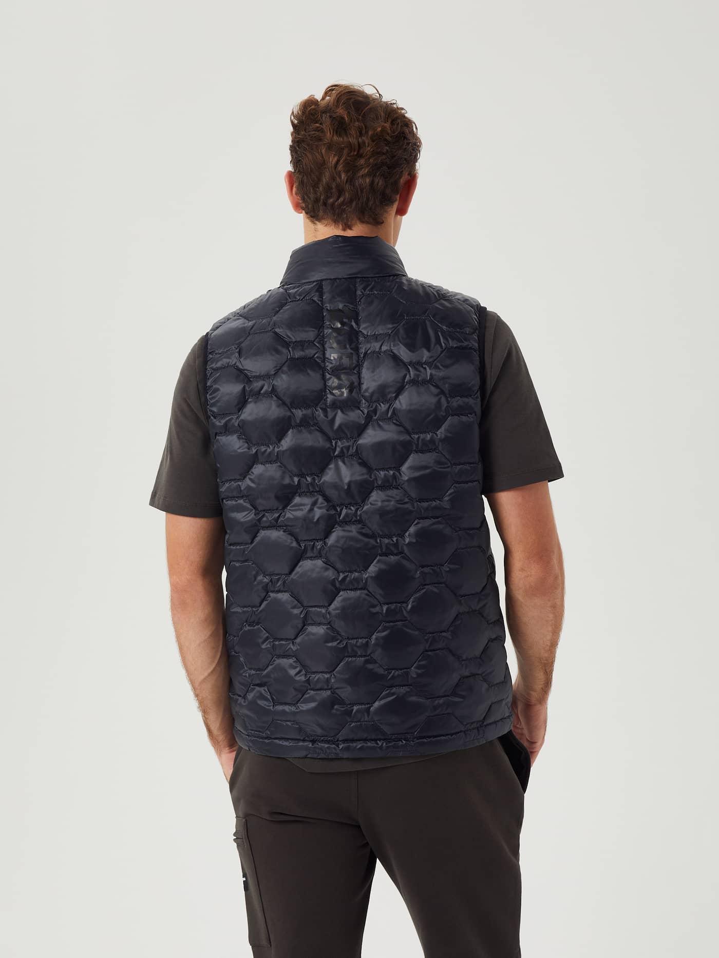 Vista posterior del Borg Down Liner Vest en Black Beauty (Negro) con acolchado hexagonal y banda con logo tonal. - Image 3