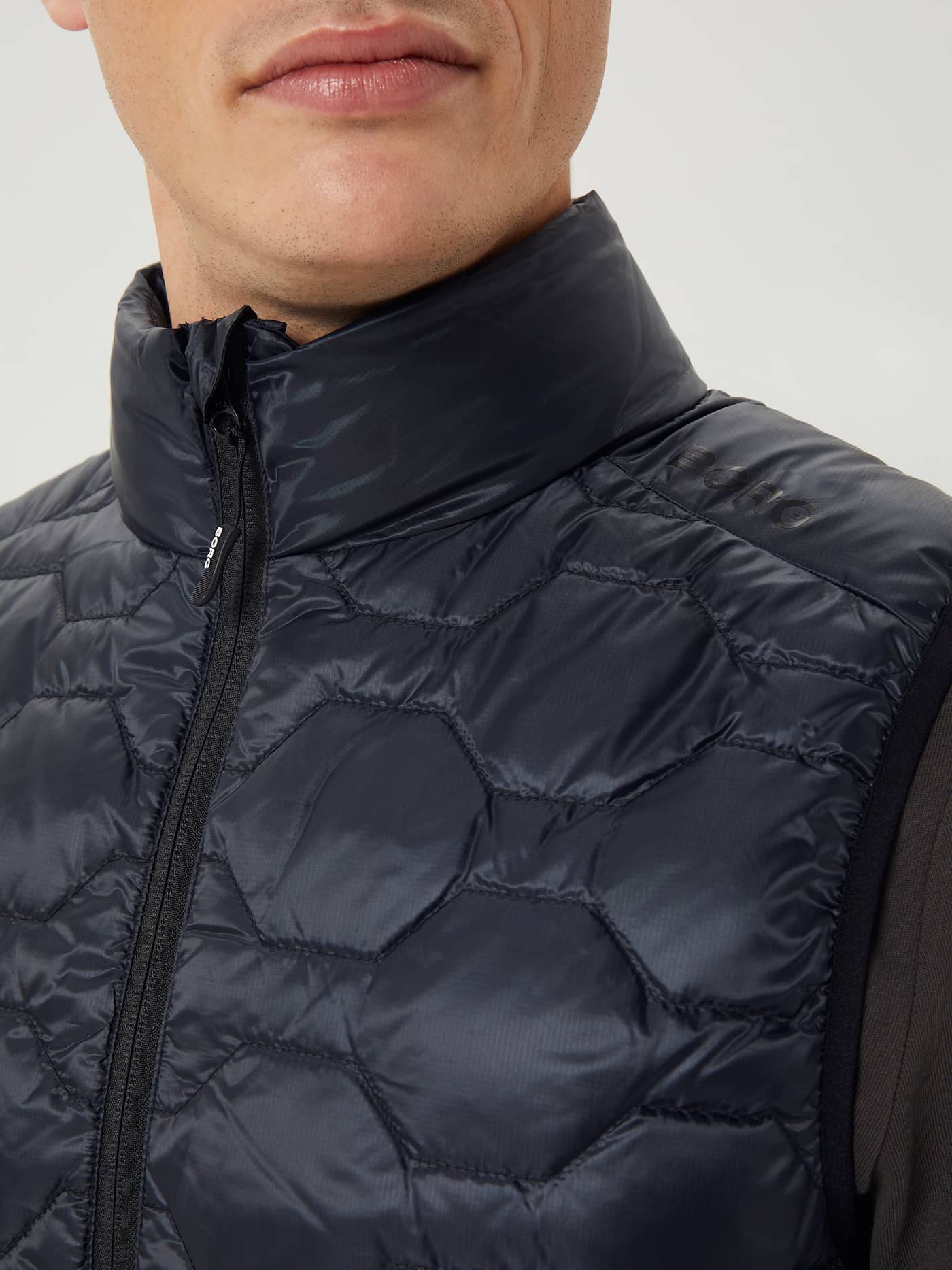 Primer plano del funcional chaleco acolchado Borg Down Liner Vest en Black Beauty (Negro) con logo negro en el hombro. - Image 6