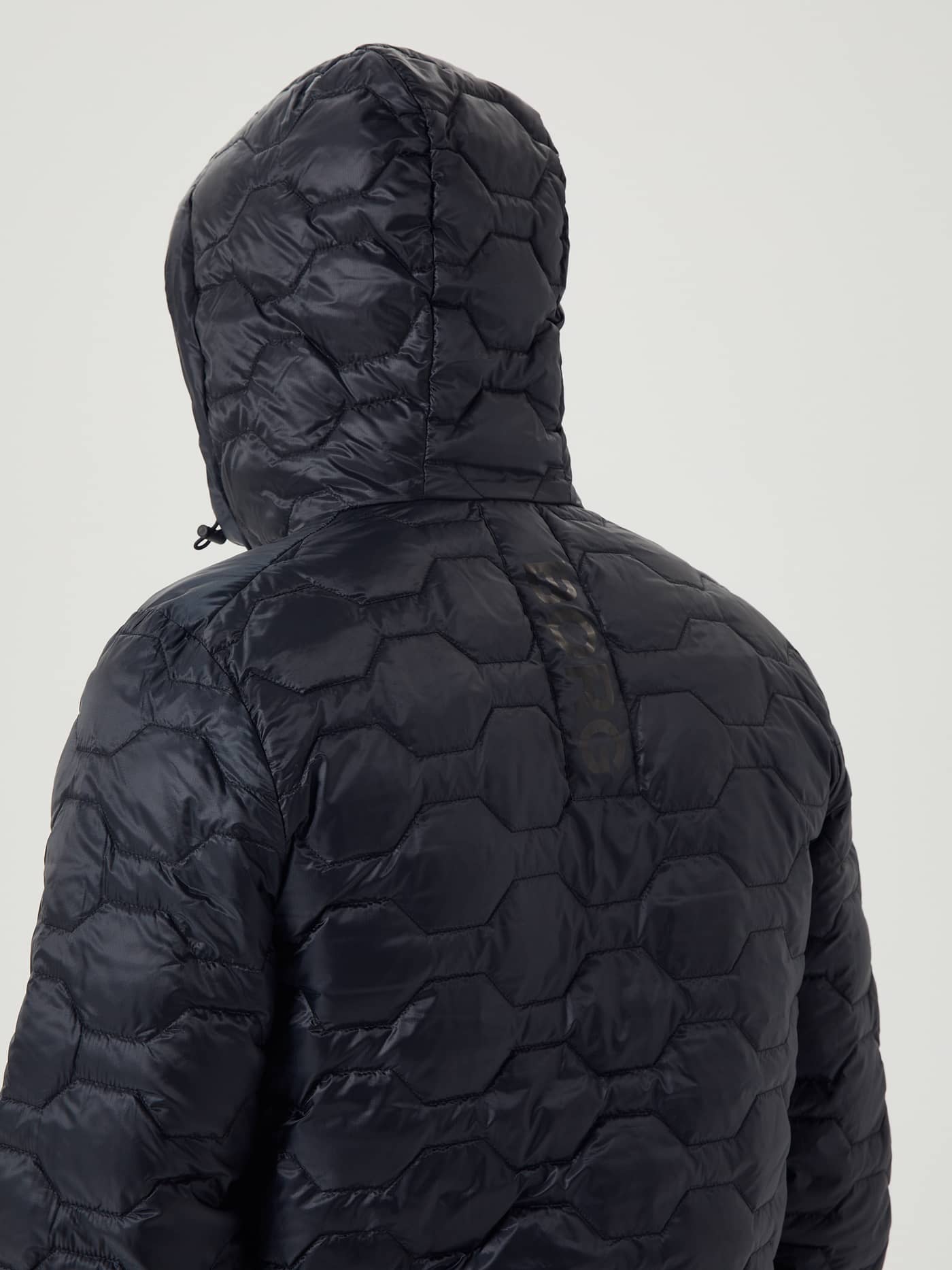 Back view of the functional men's Borg Down Liner Jacket in Black Beauty (Black) with hexagonal quilting and a black logo. - Image 6