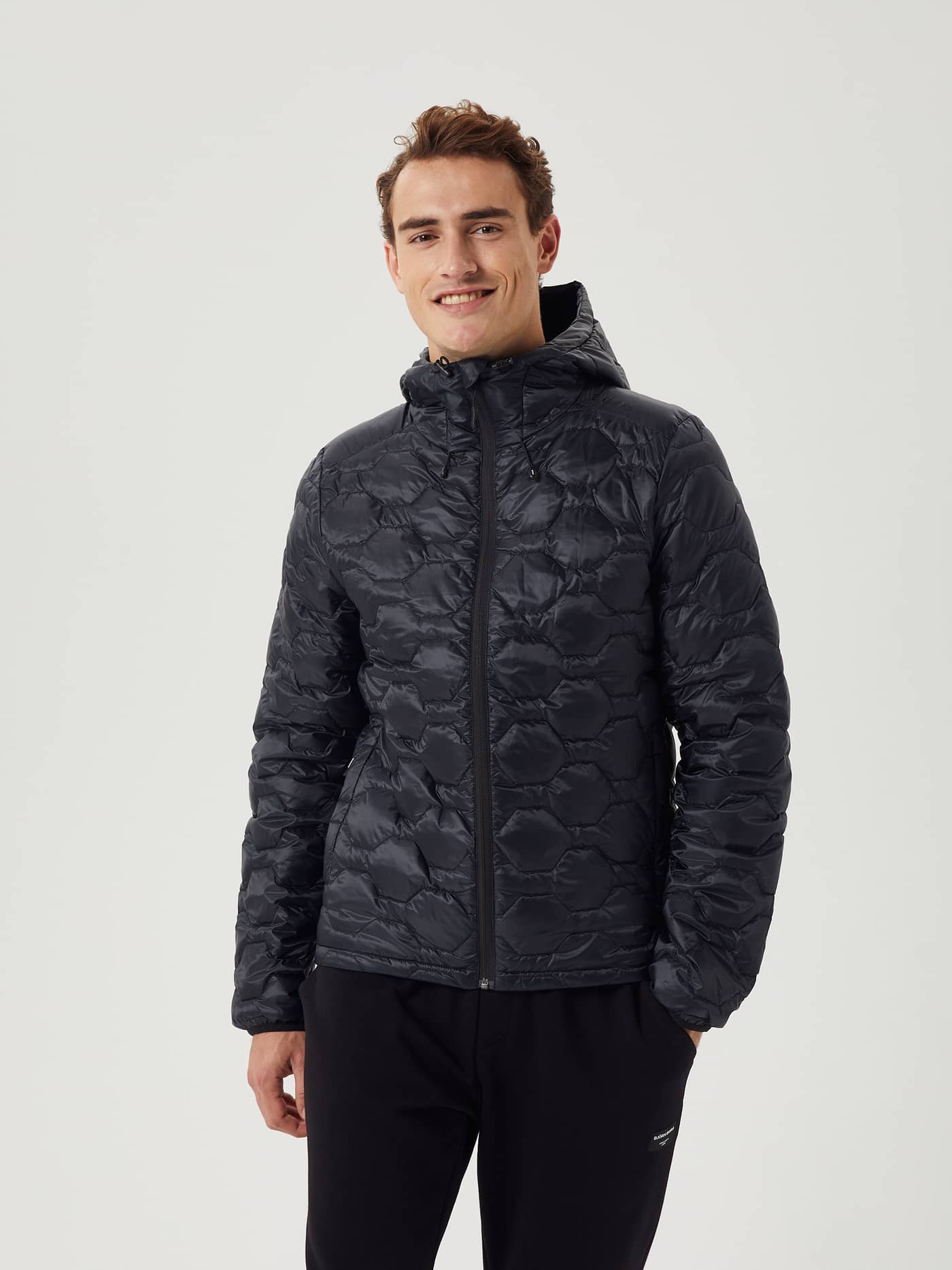Front view of a man wearing the Björn Borg Down Liner Jacket in Black Beauty (Black) with a functional quilted finish. - Image 3