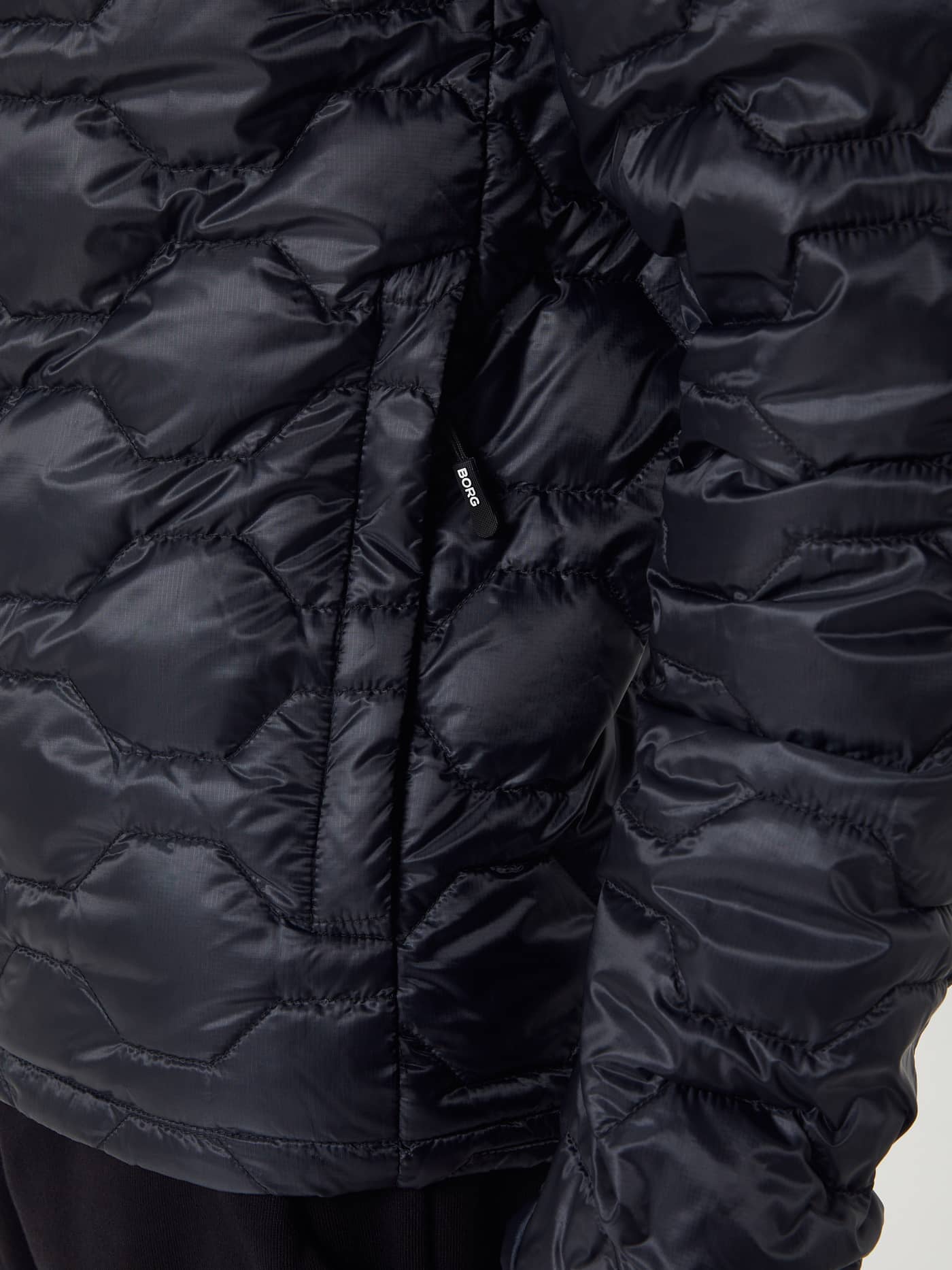 Detailed close-up of the men's quilted Borg Down Liner Jacket in Black Beauty (Black) with a white logo on the pocket. - Image 8