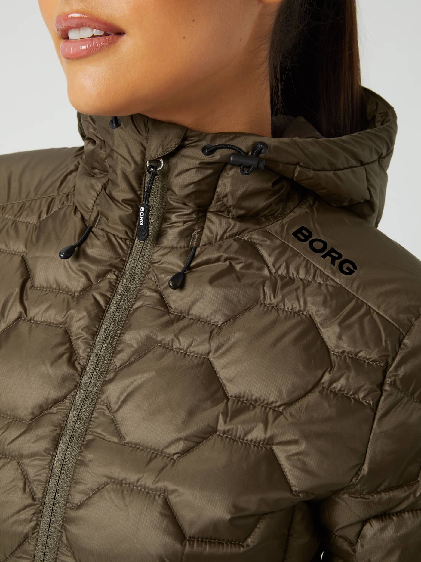 Close-up of the women's Borg Down Liner Jacket in Tarmac (Brown) with honeycomb quilting and a black shoulder logo. - Image 4