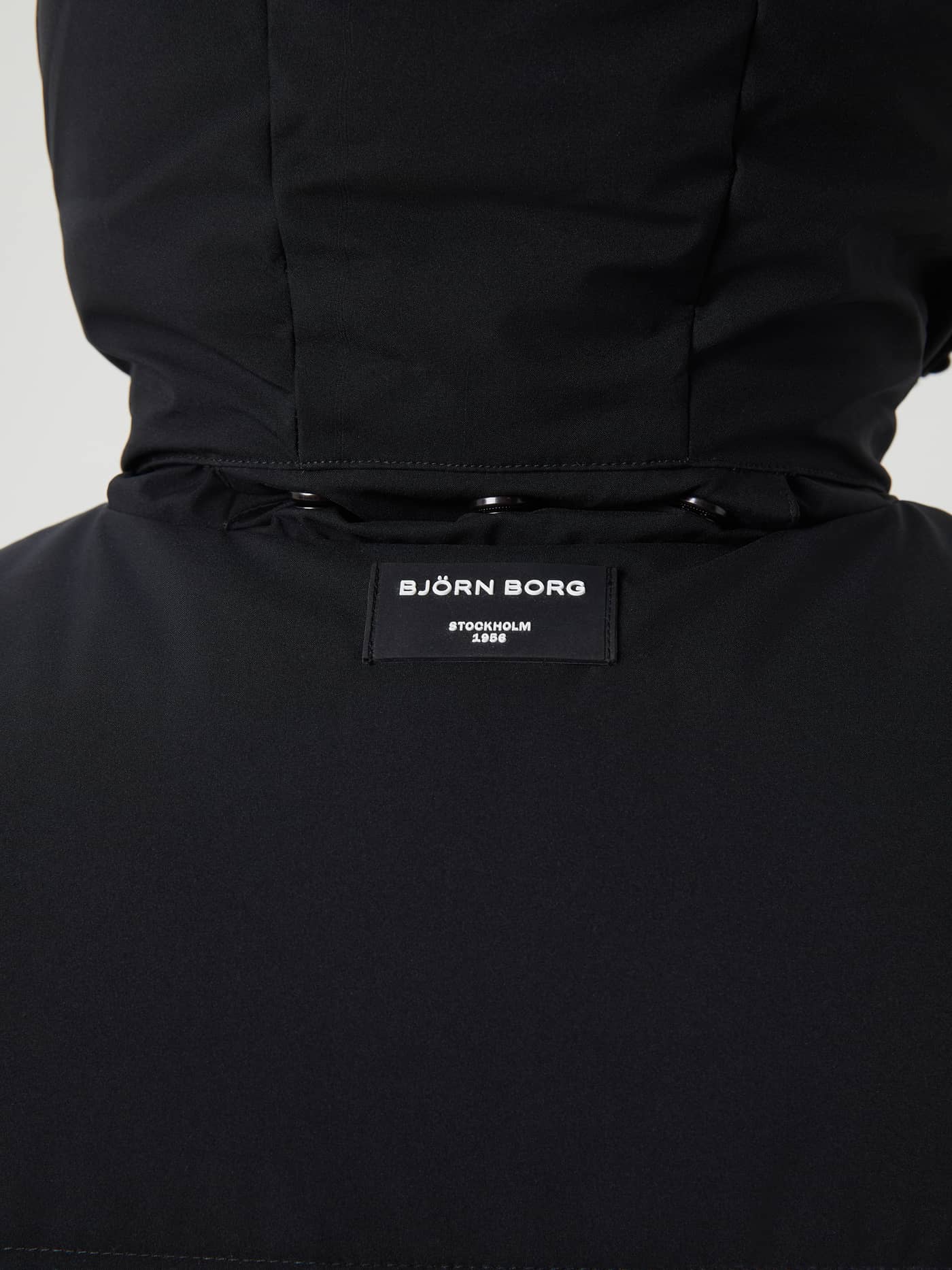 Detailed close-up of the back logo label on the Björn Borg Centre Puffer Jacket in Black Beauty (Black). - Image 6