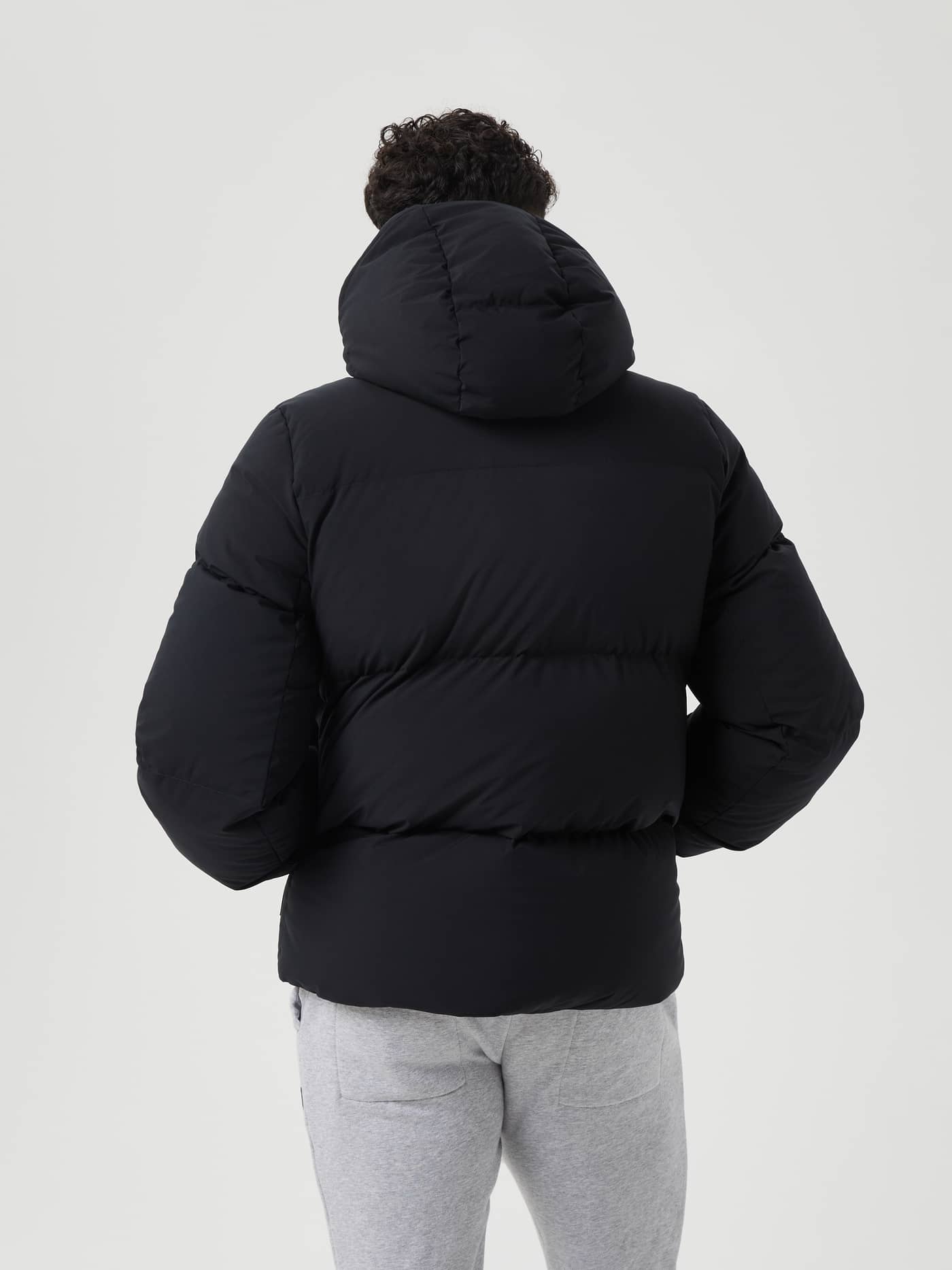 Back view of a man in the stylish and functional, down-filled Björn Borg Centre Puffer Jacket in Black Beauty (Black). - Image 3