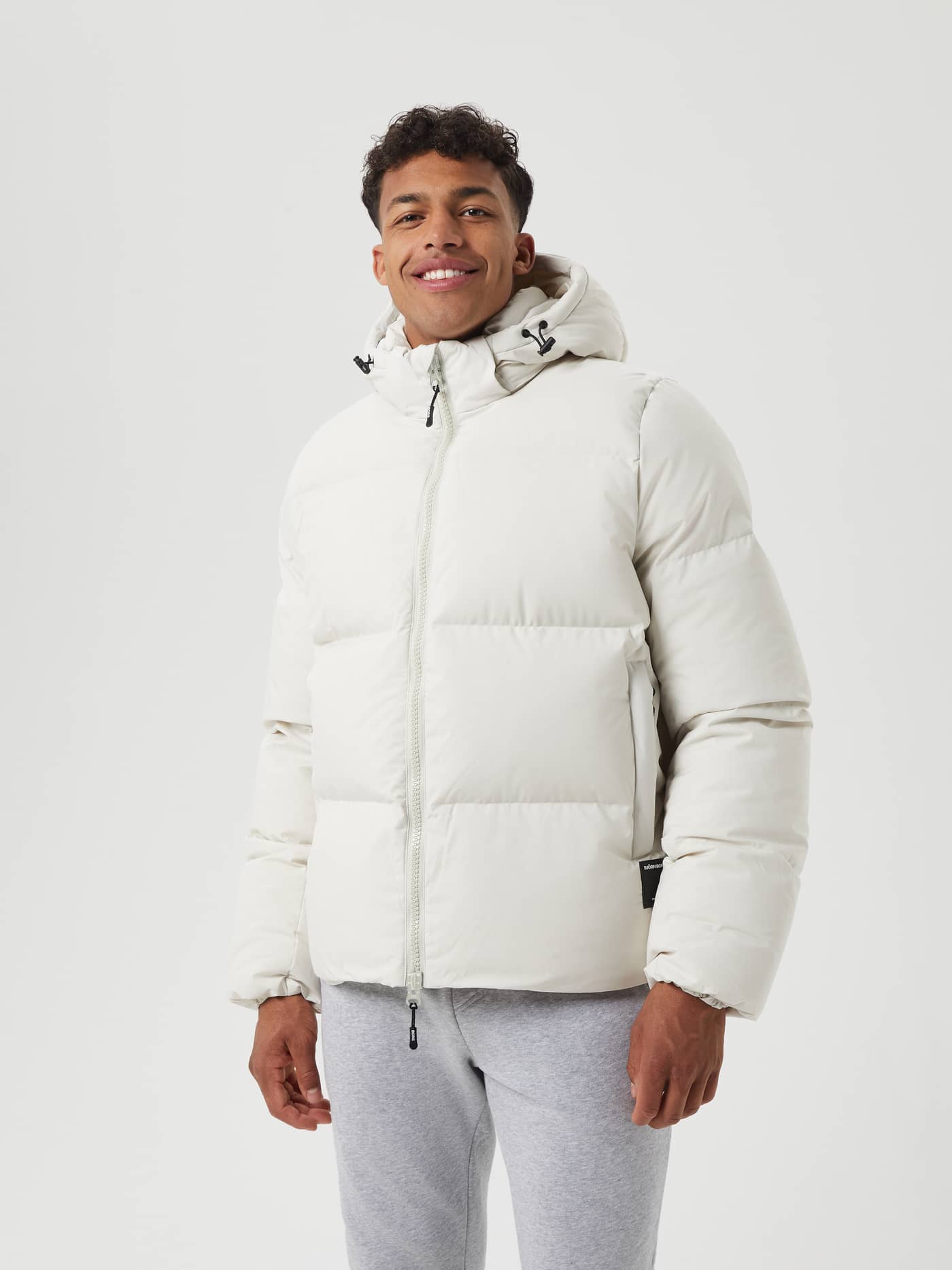 Vooraanzicht van een man in de Björn Borg Centre Puffer Jacket in Silver Birch (Wit), een stijlvol en functioneel donsjack. - Image 1