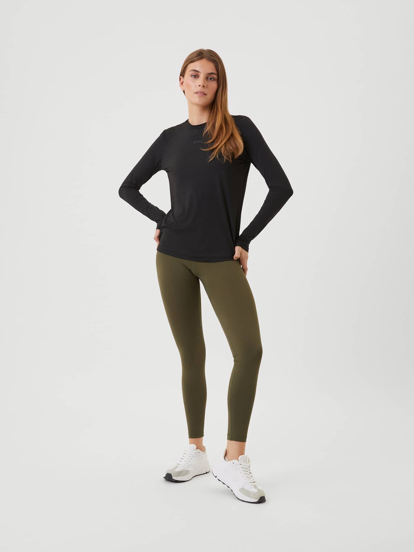 Full body front view of a model wearing the black Borg Long Sleeve T-shirt and green leggings. - Image 3