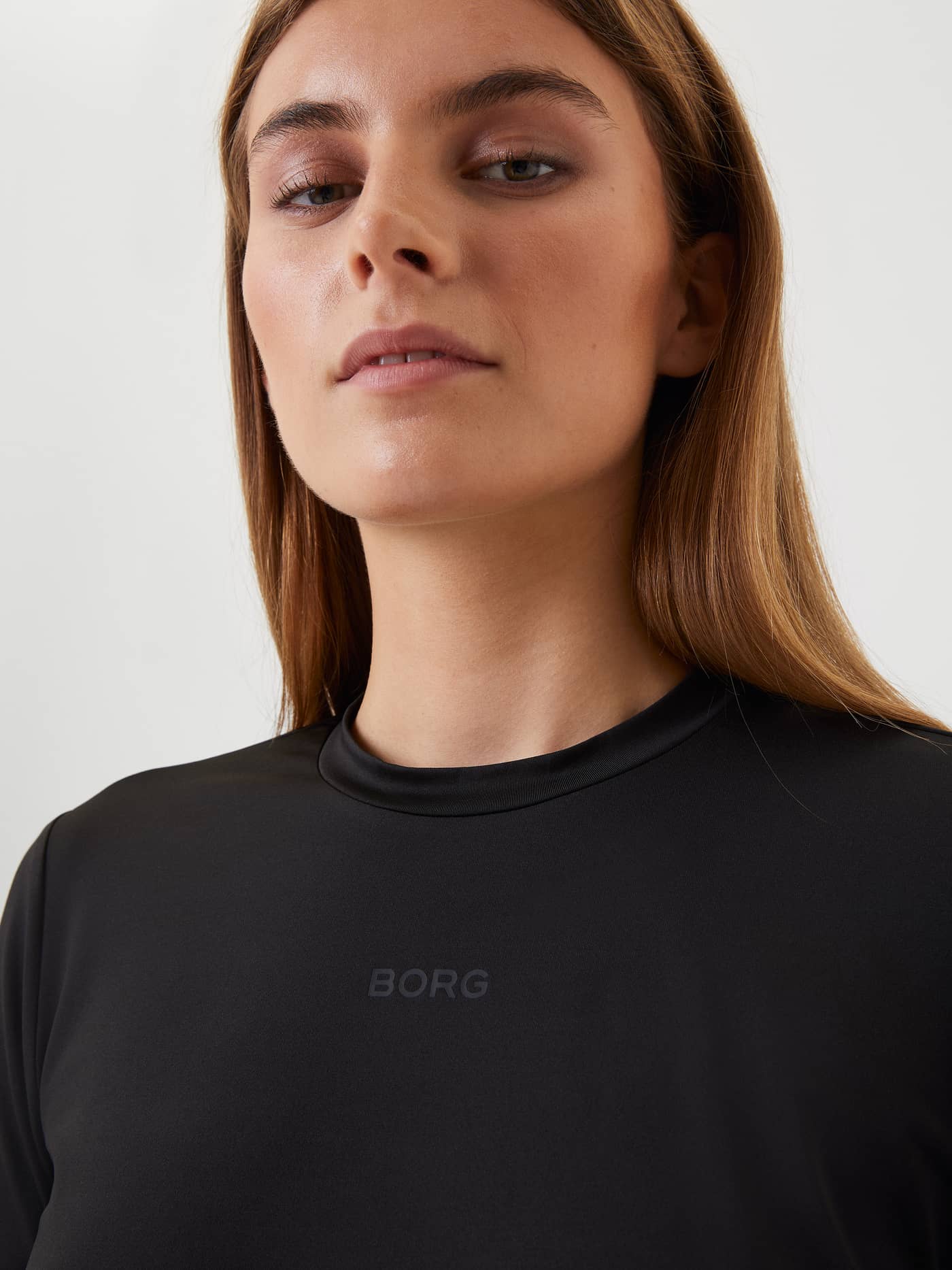 Close-up of a woman wearing the black Borg Long Sleeve T-shirt, focusing on the subtle BORG logo on the chest. - Image 4