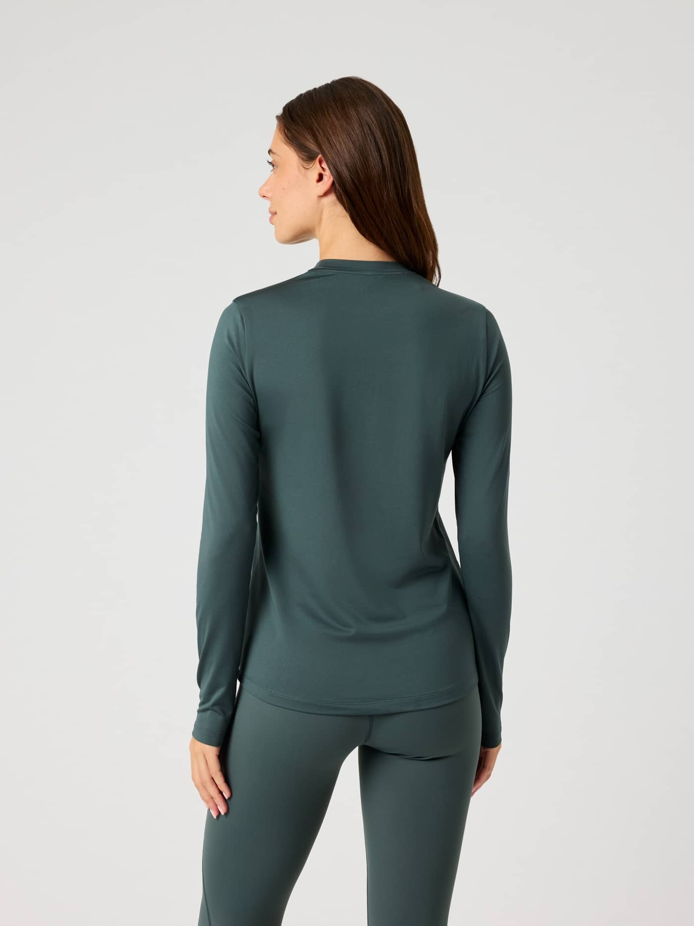Back view of a woman wearing the Borg Long Sleeve T-Shirt in Urban Chic (Green), a stylish training top with a regular fit. - Image 2