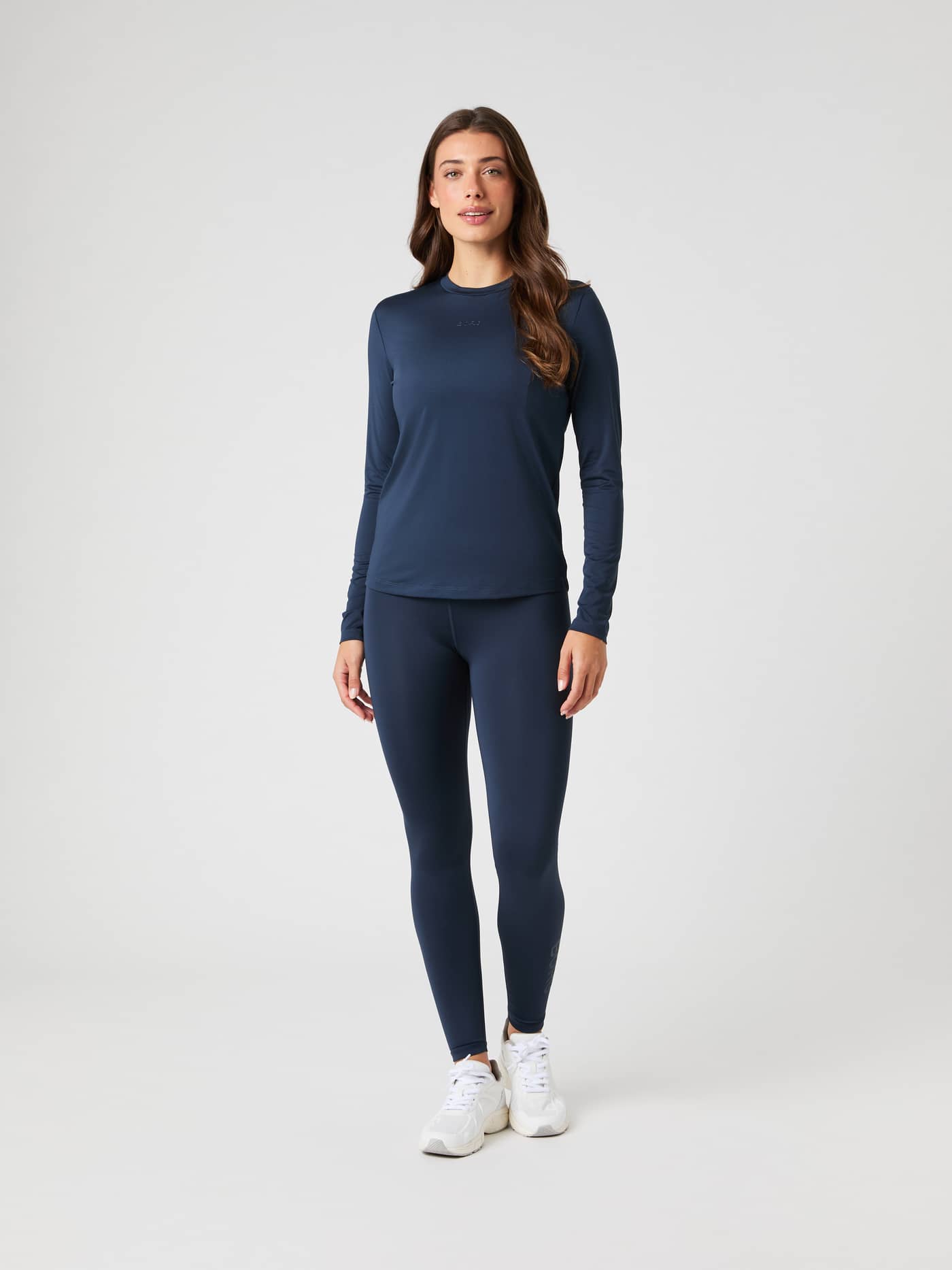 Full-body front view of a woman wearing the Björn Borg Borg Long Sleeve T-shirt in dark navy, paired with matching leggings. - Image 3