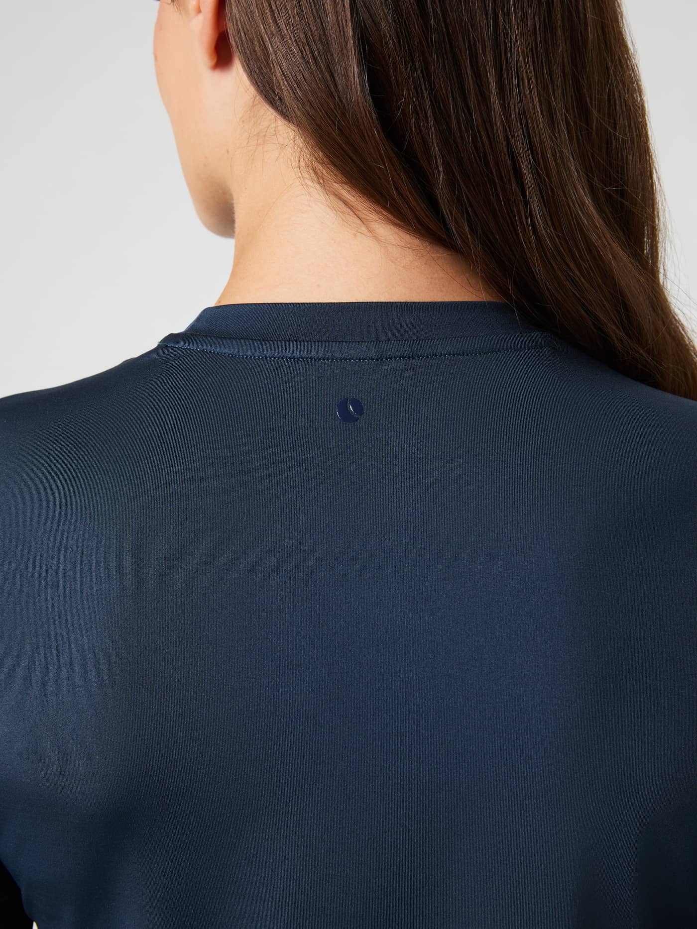 Close-up of the back of the navy Borg Long Sleeve T-Shirt, showcasing the subtle logo detail below the neckline. - Image 5