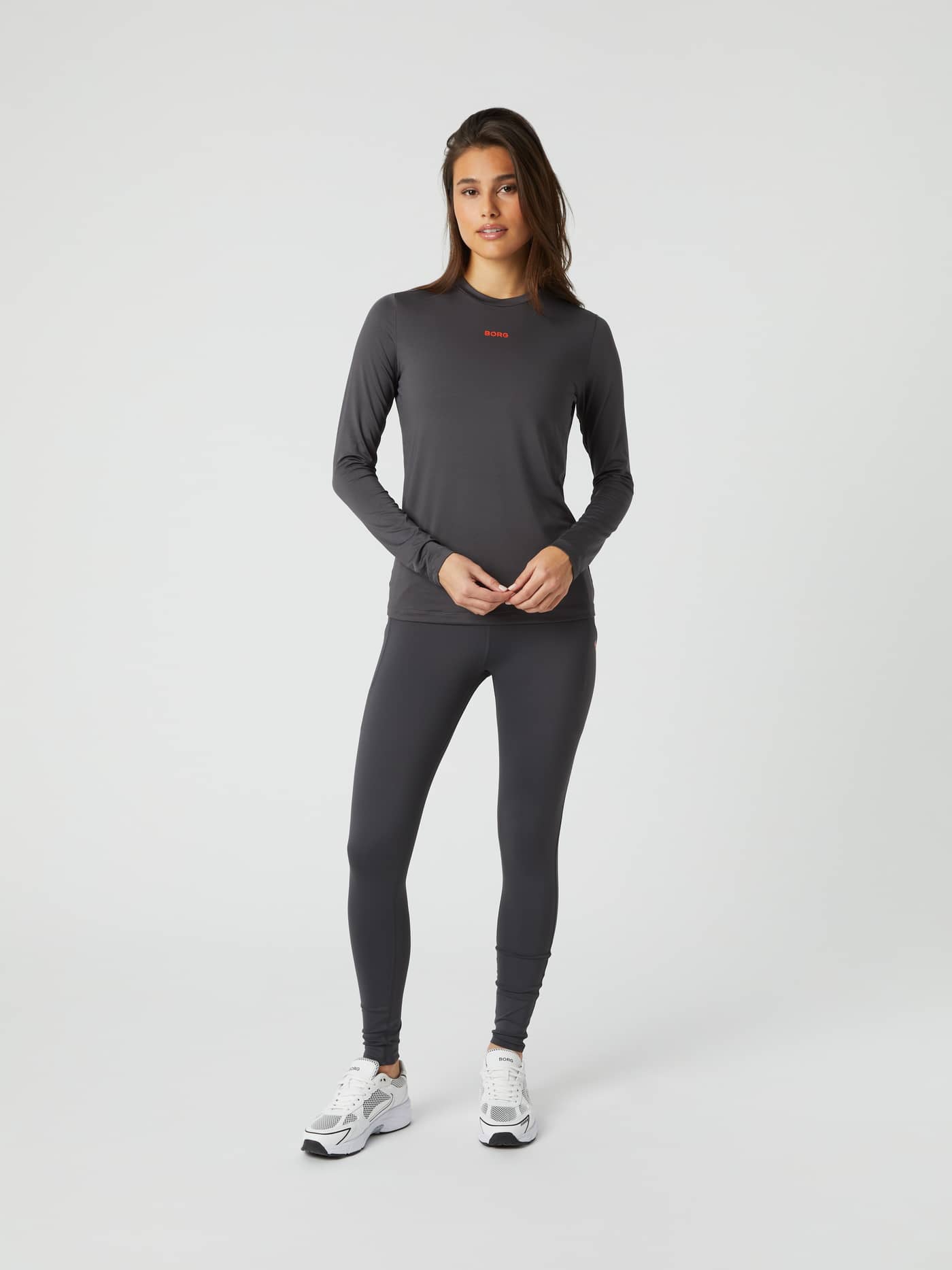 Full body front view of a woman wearing the Borg Long Sleeve T-shirt in dark grey. - Image 4