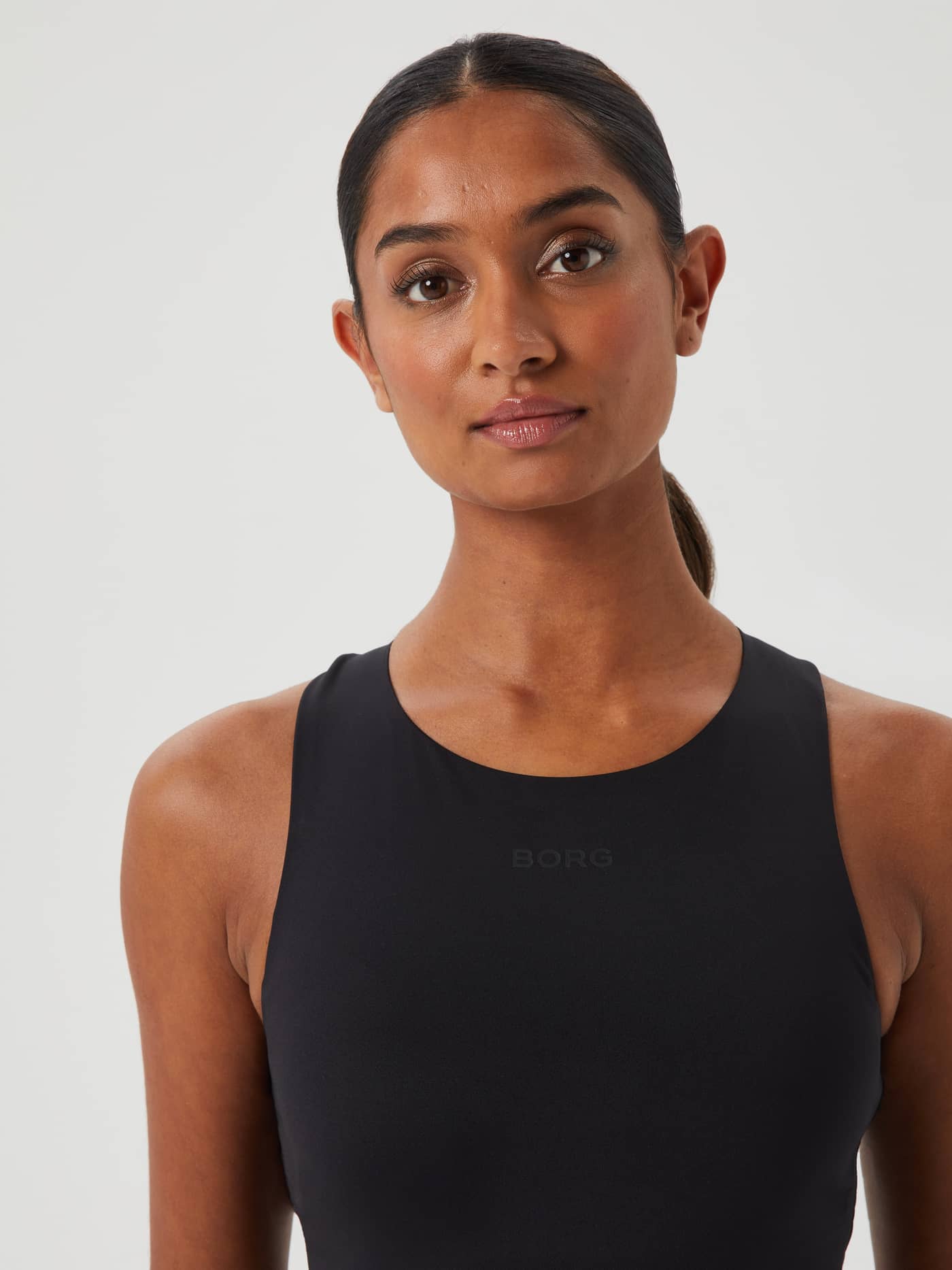 Nahaufnahme des Studio 2 In 1 Tank in Black Beauty (Schwarz), ein schmales Training-Top mit tonalem Borg-Logo. - Image 3