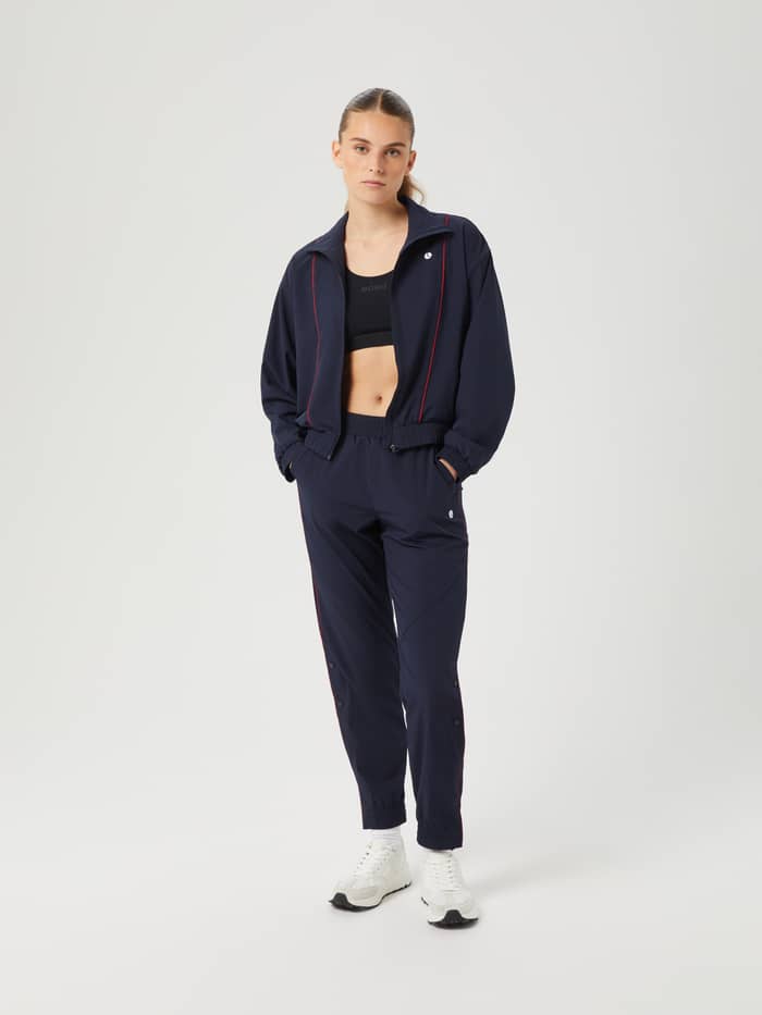Ganzkörper-Vorderansicht der Ace Woven Track Jacket in Night sky (Marineblau) mit weißem Tennisball-Logo für Tennis. - Image 3