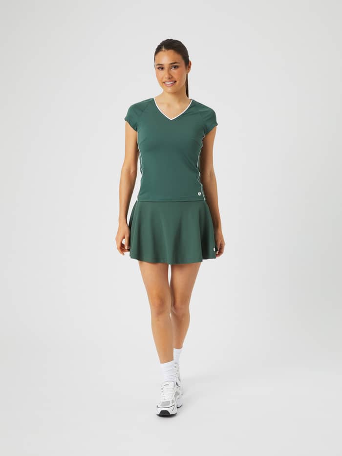 Slim-fit Björn Borg Ace V T-Shirt in Cilantro (Groen) met een tennisrokje, getoond in een volledig vooraanzicht. - Image 4