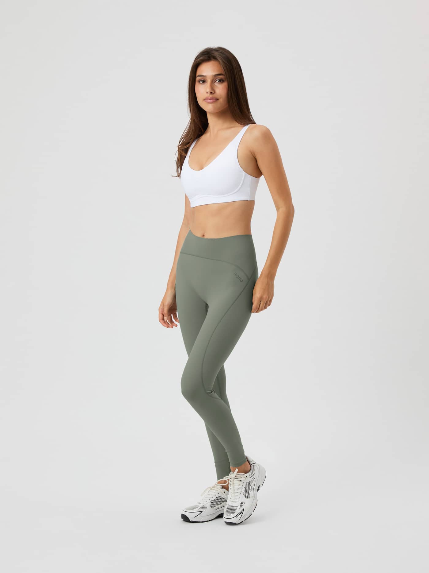 Vue en pied d'une femme portant le Borg Reform Sports Bra en Brilliant White (Blanc) pour une tenue de training stylée. - Image 4