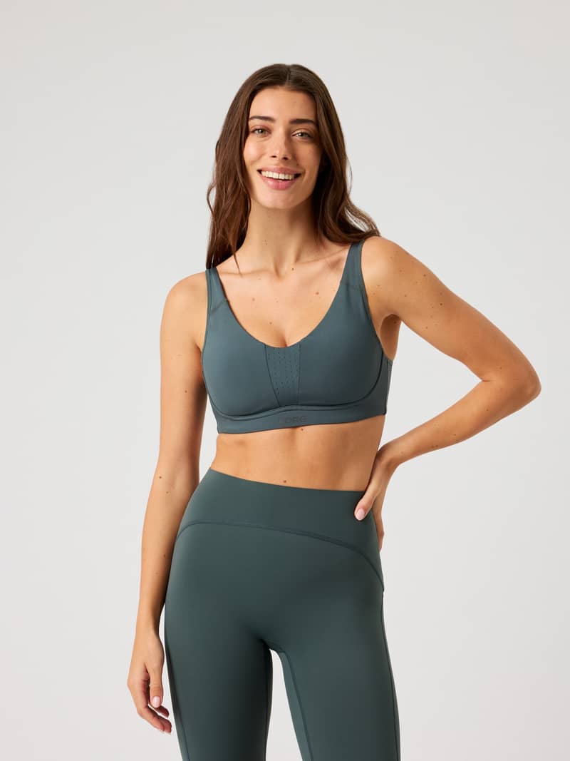Front view of a model wearing the green Björn Borg Reform Sports Bra, a stylish training top offering a medium support fit.