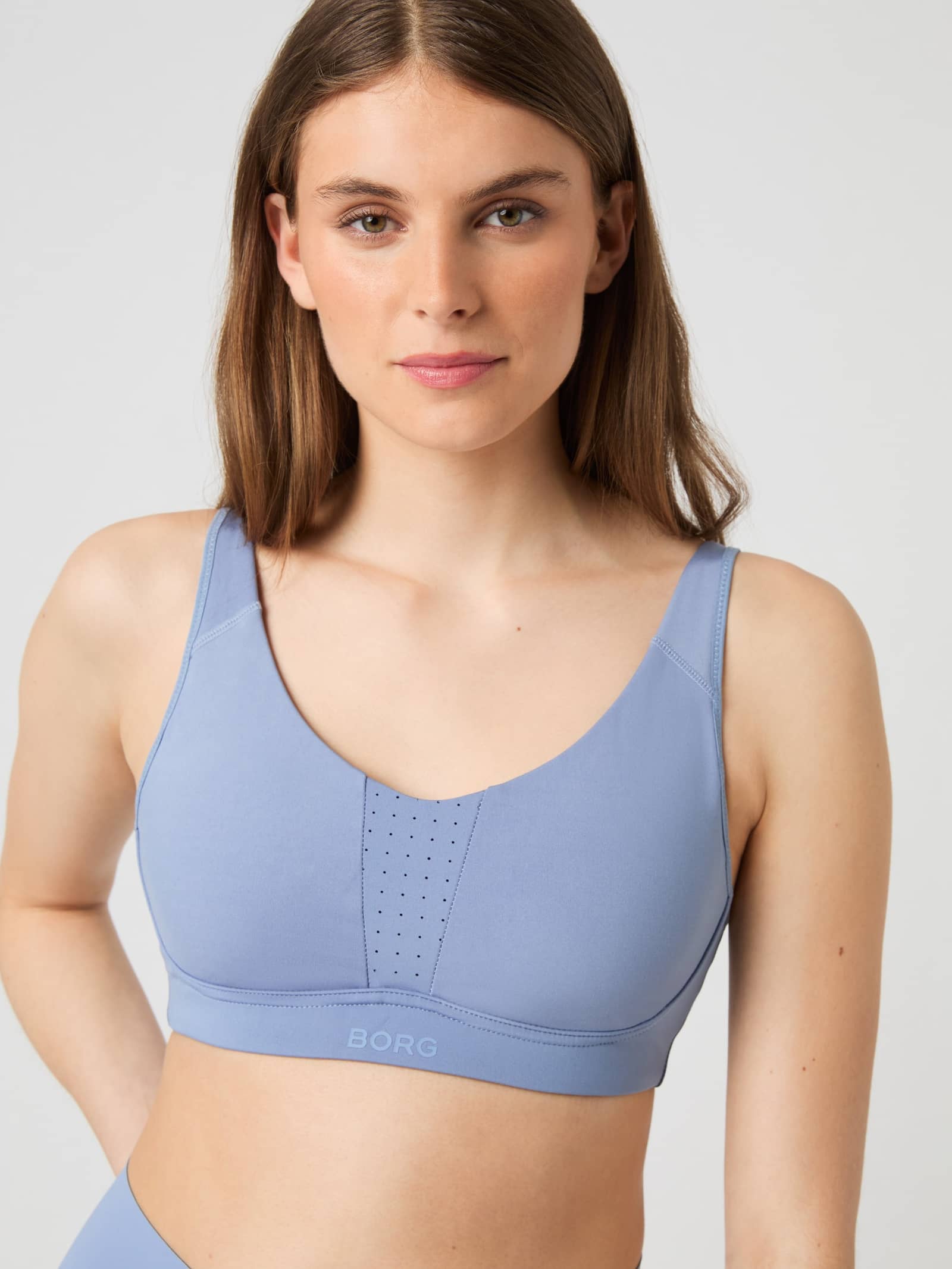 Close-up front view of a model wearing the Borg Reform Sports Bra in Stonewash. - Image 1