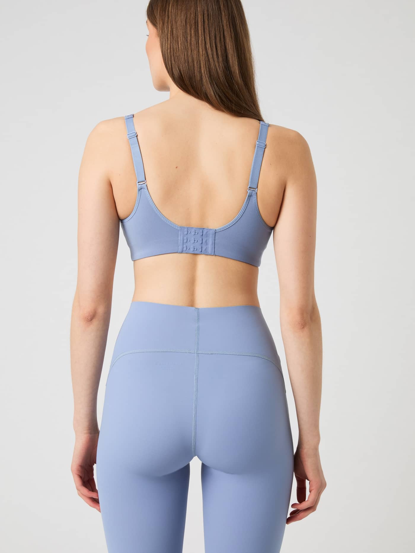 Back view of the Borg Reform Sports Bra in Stonewash, showing its adjustable straps and hook-and-eye closure. - Image 5