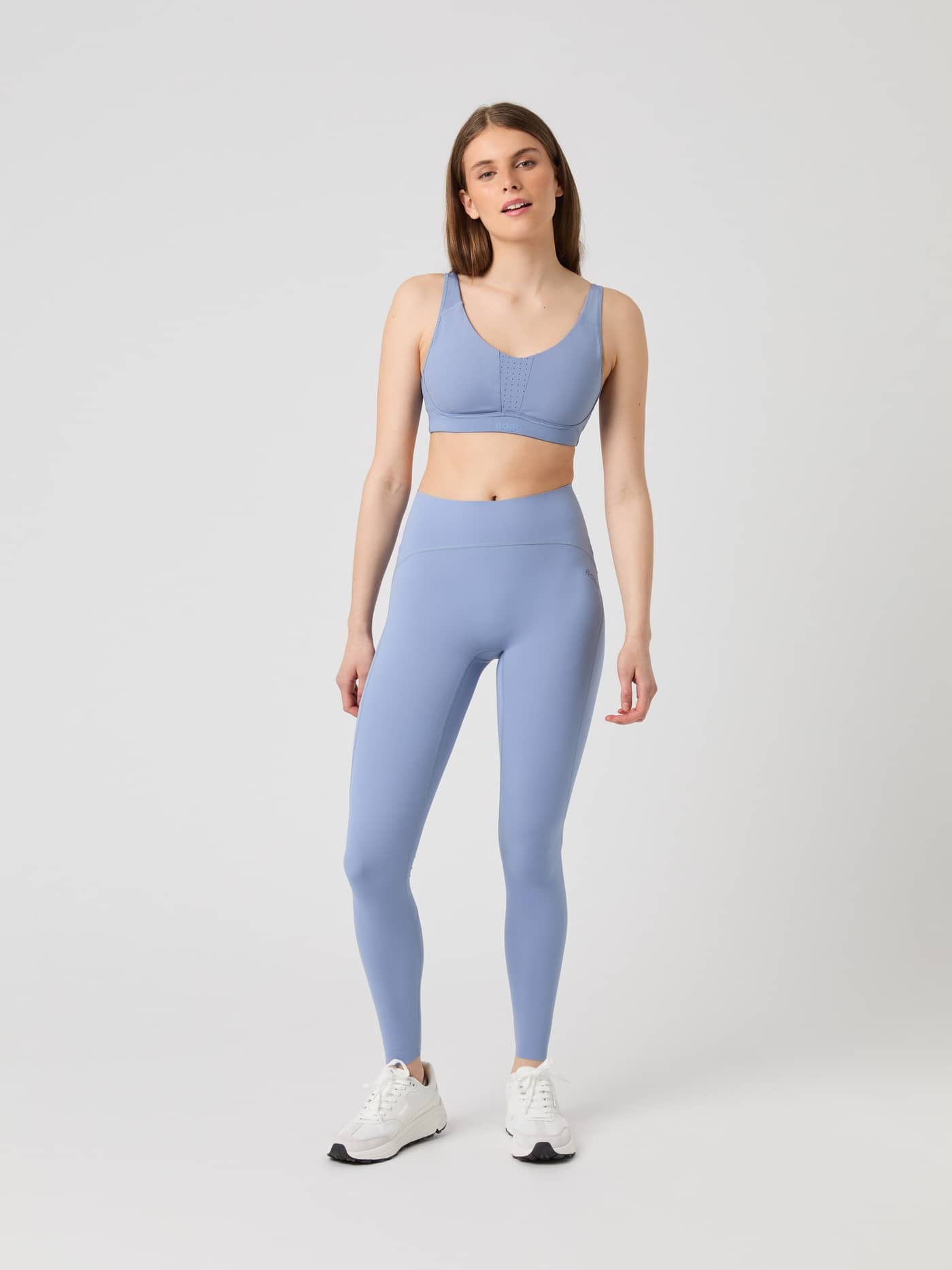 Model seen from the front wearing the Borg Reform Sports Bra in Stonewash blue, paired with matching leggings. - Image 4